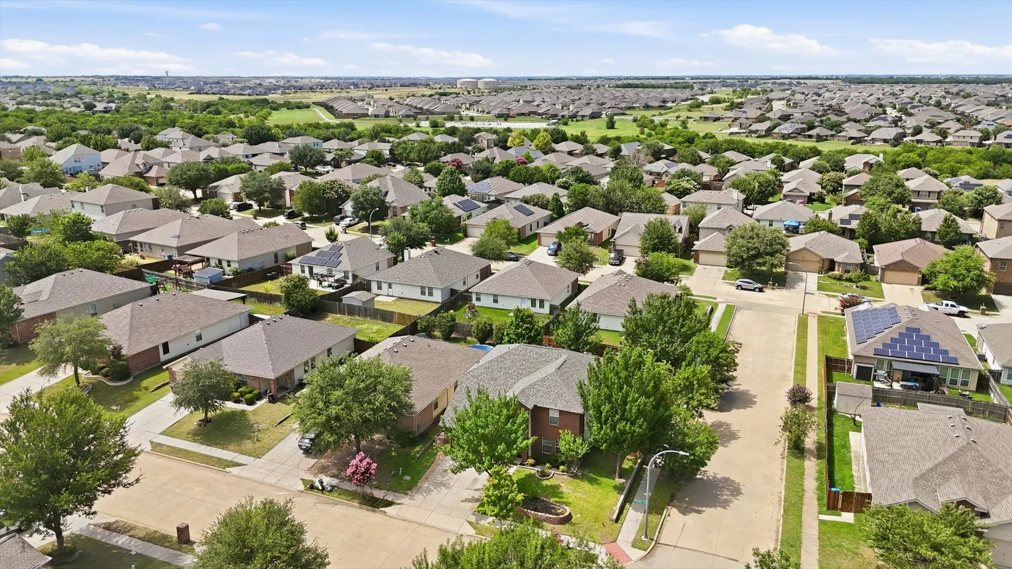 Expansive residential area featuring numerous single-family homes, mature trees, and paved streets