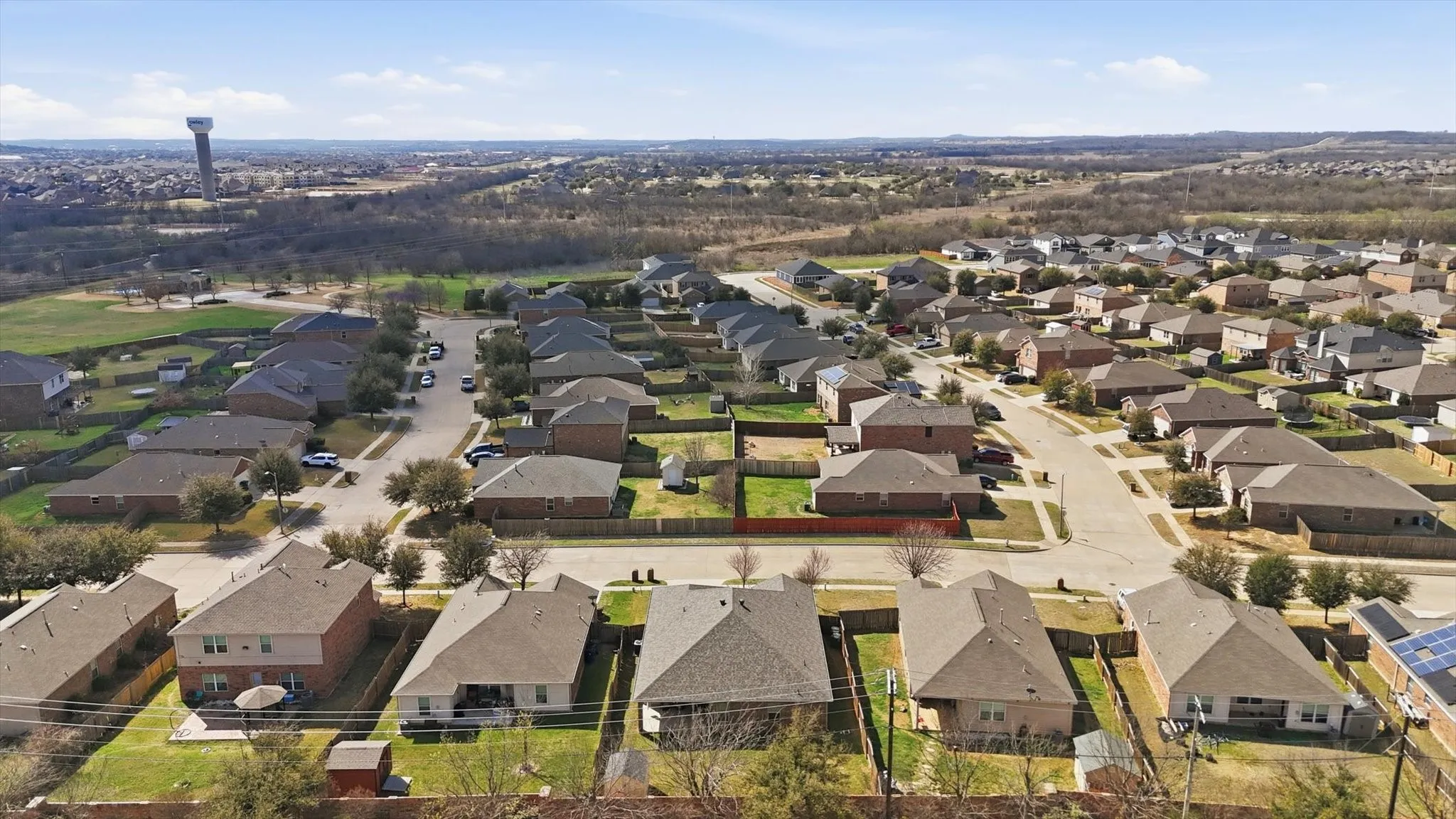 Residential neighborhood featuring single-story and two-story homes with shingle roofs and fenced backyards