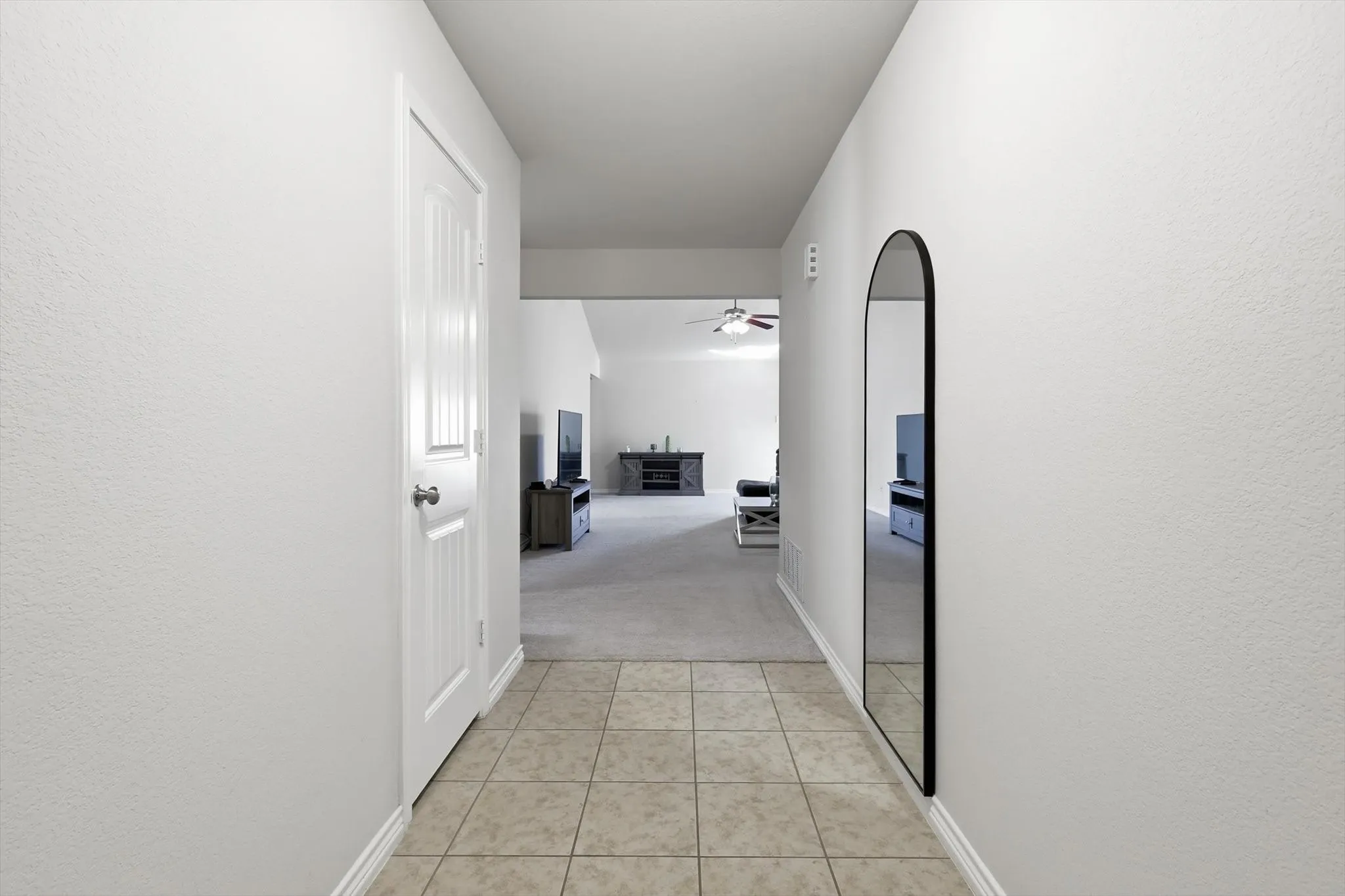 Tiled entryway flooring extending into a carpeted interior space