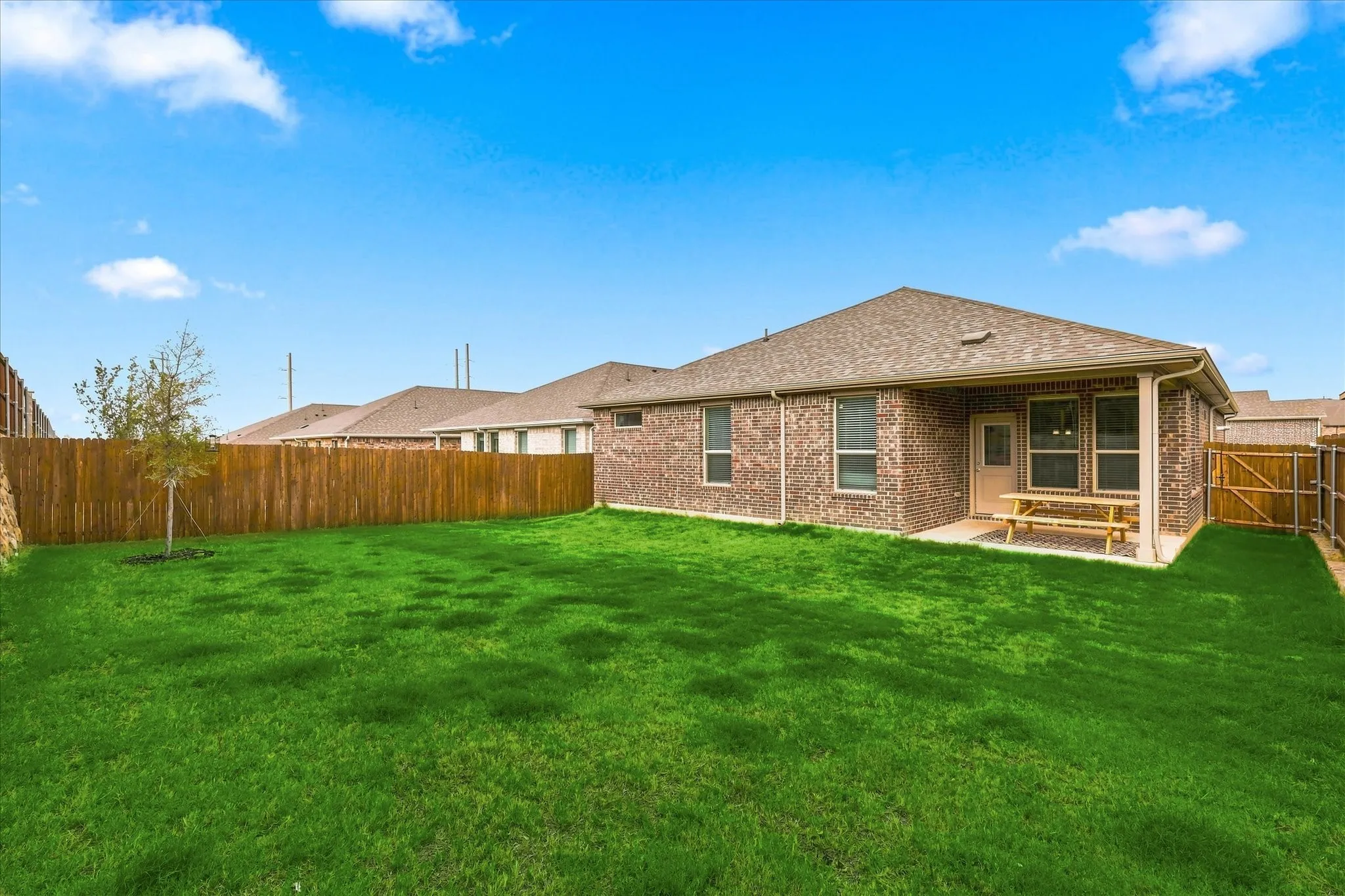 Brick exterior with an attached covered patio featuring a concrete surface