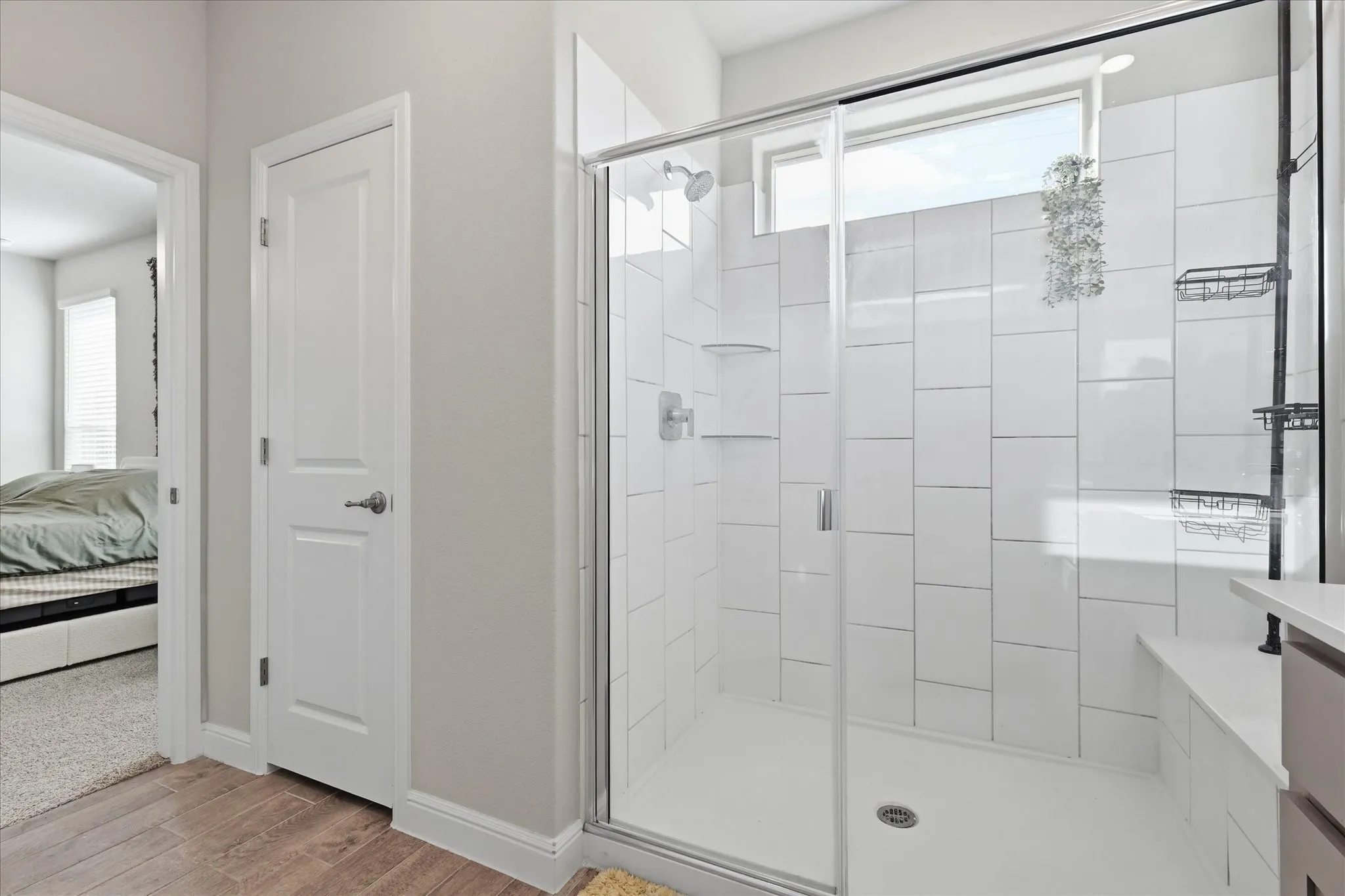 Walk-in shower with clear glass enclosure, white subway tile surround, integrated shower bench, and a transom window