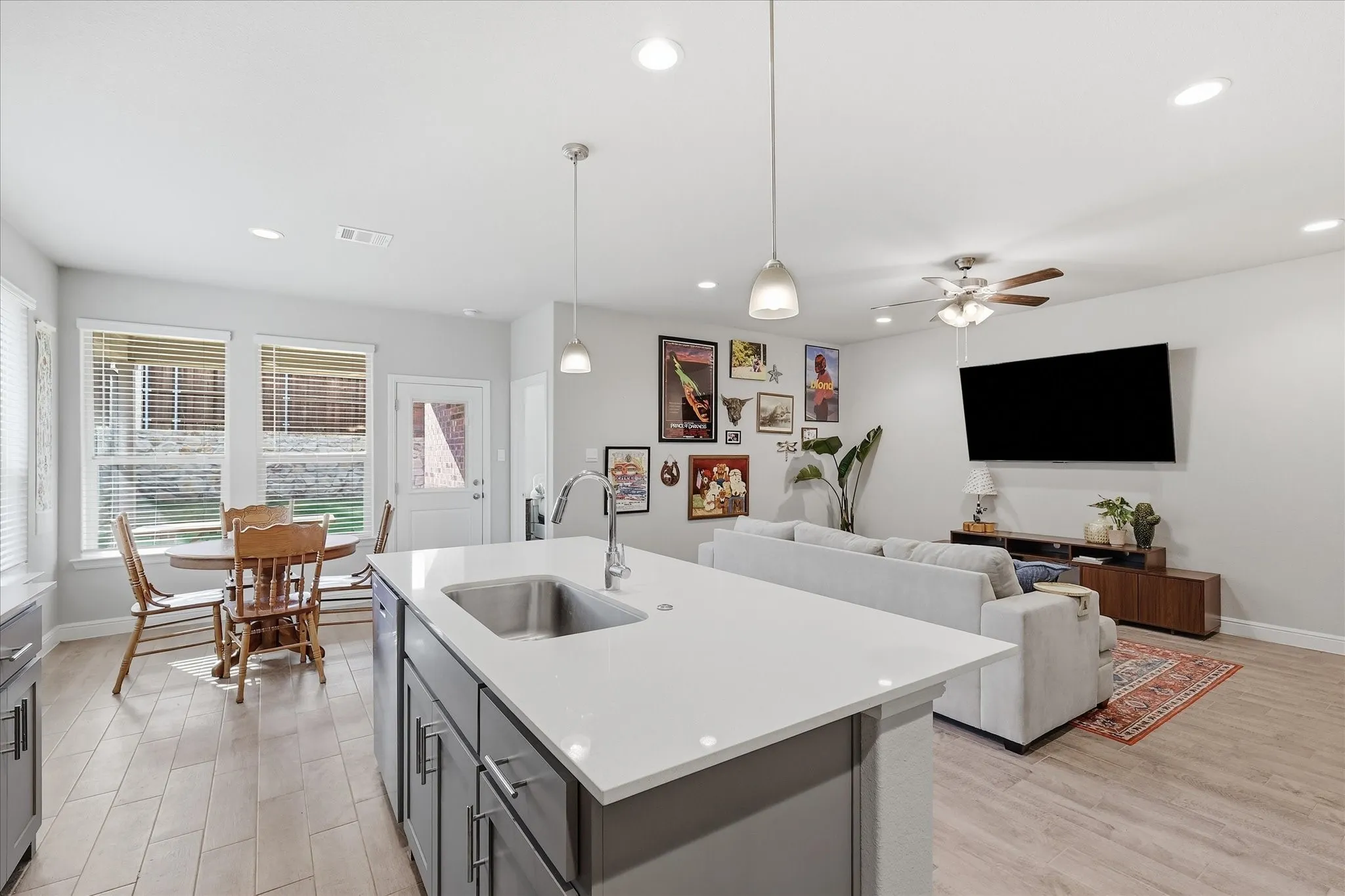 Open-concept living space with wood-finish flooring, recessed lighting, and a ceiling fan