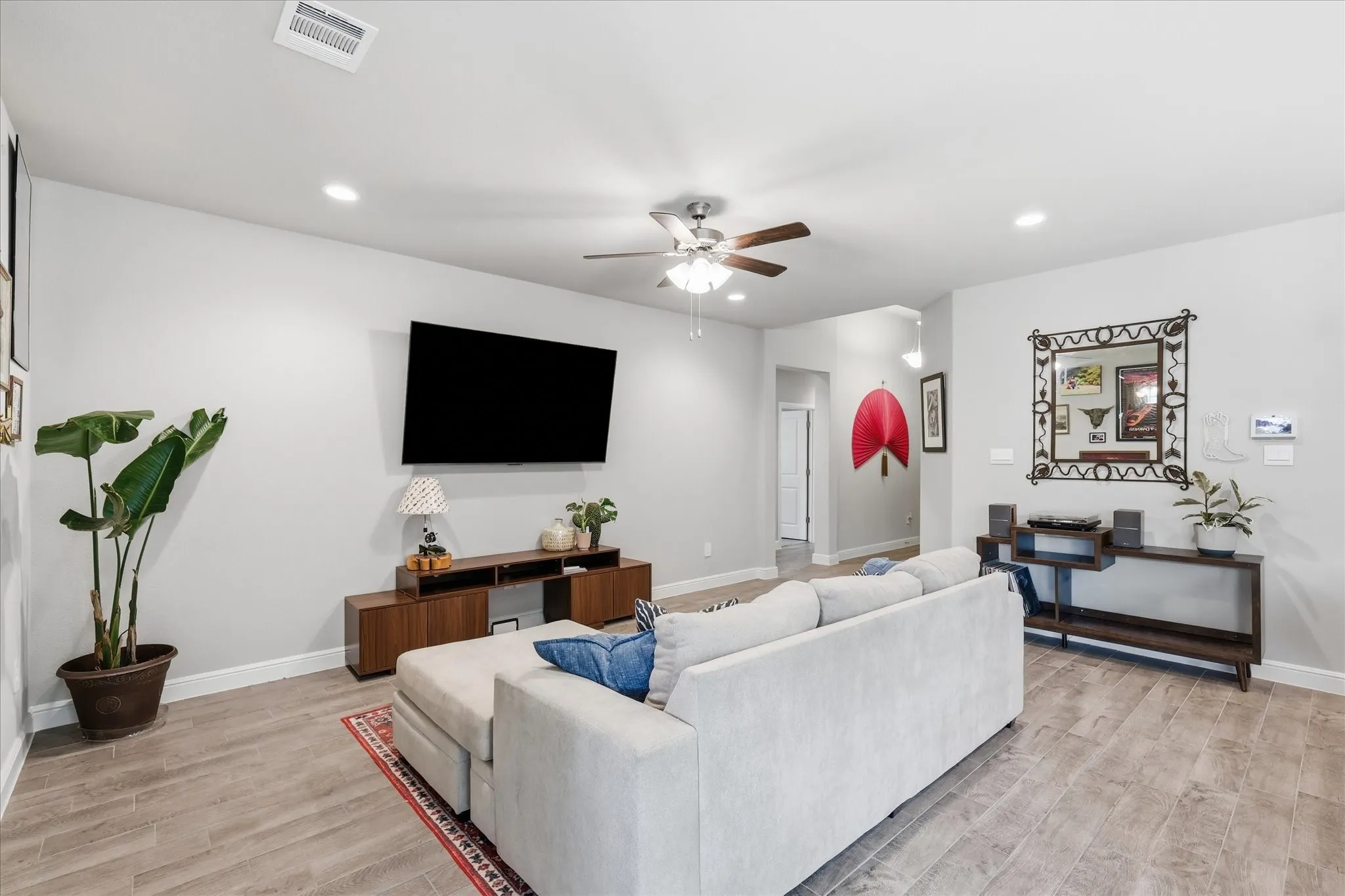 Recessed lighting, wood-finish flooring, and a ceiling fan
