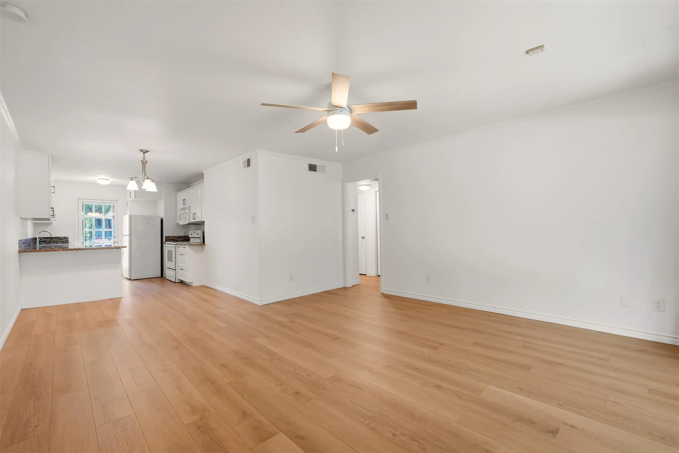 Open-concept living area featuring wood-finish flooring, a ceiling fan, and recessed lighting