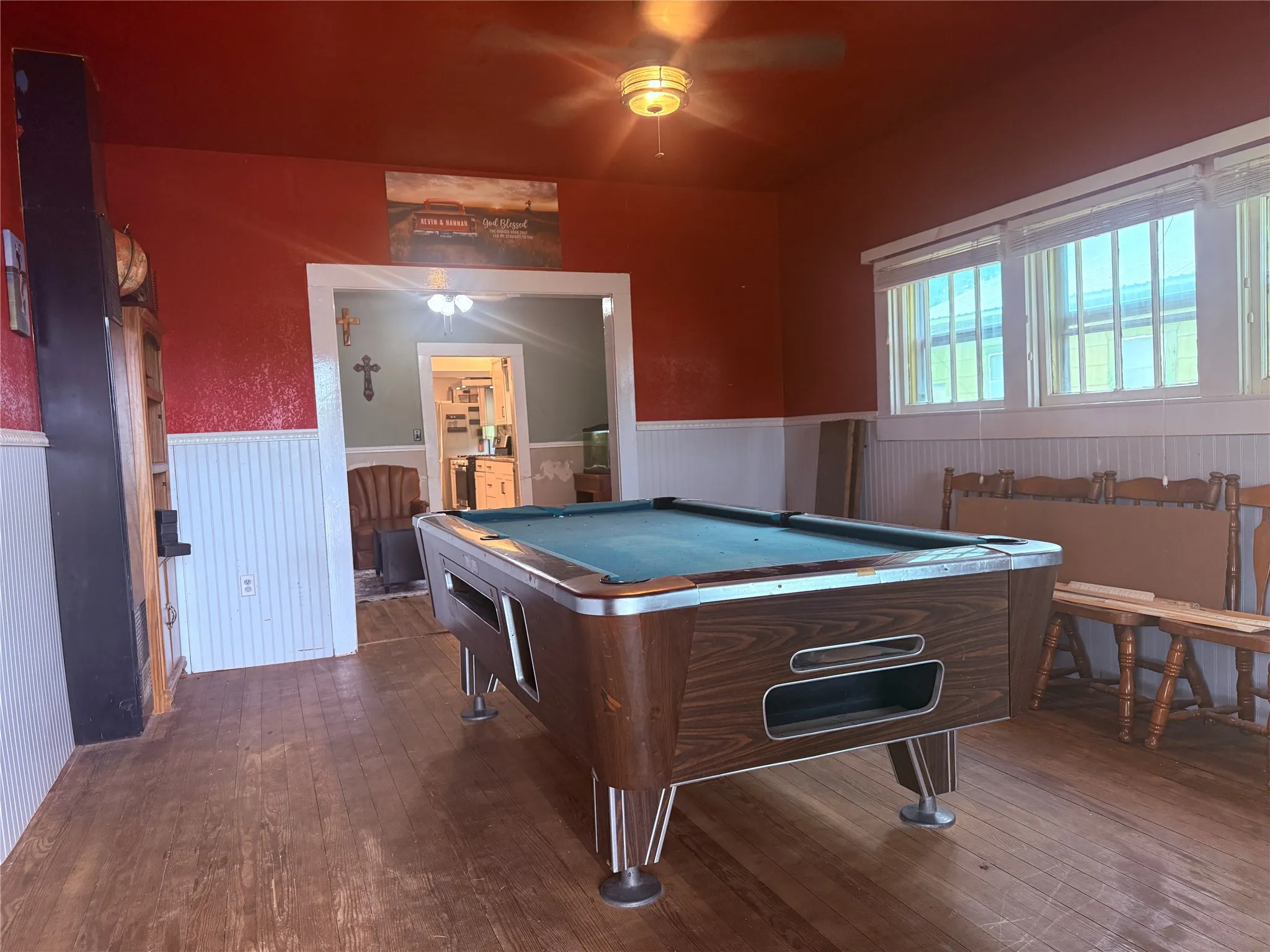 Wood-finish flooring with white wainscoting and a red ceiling