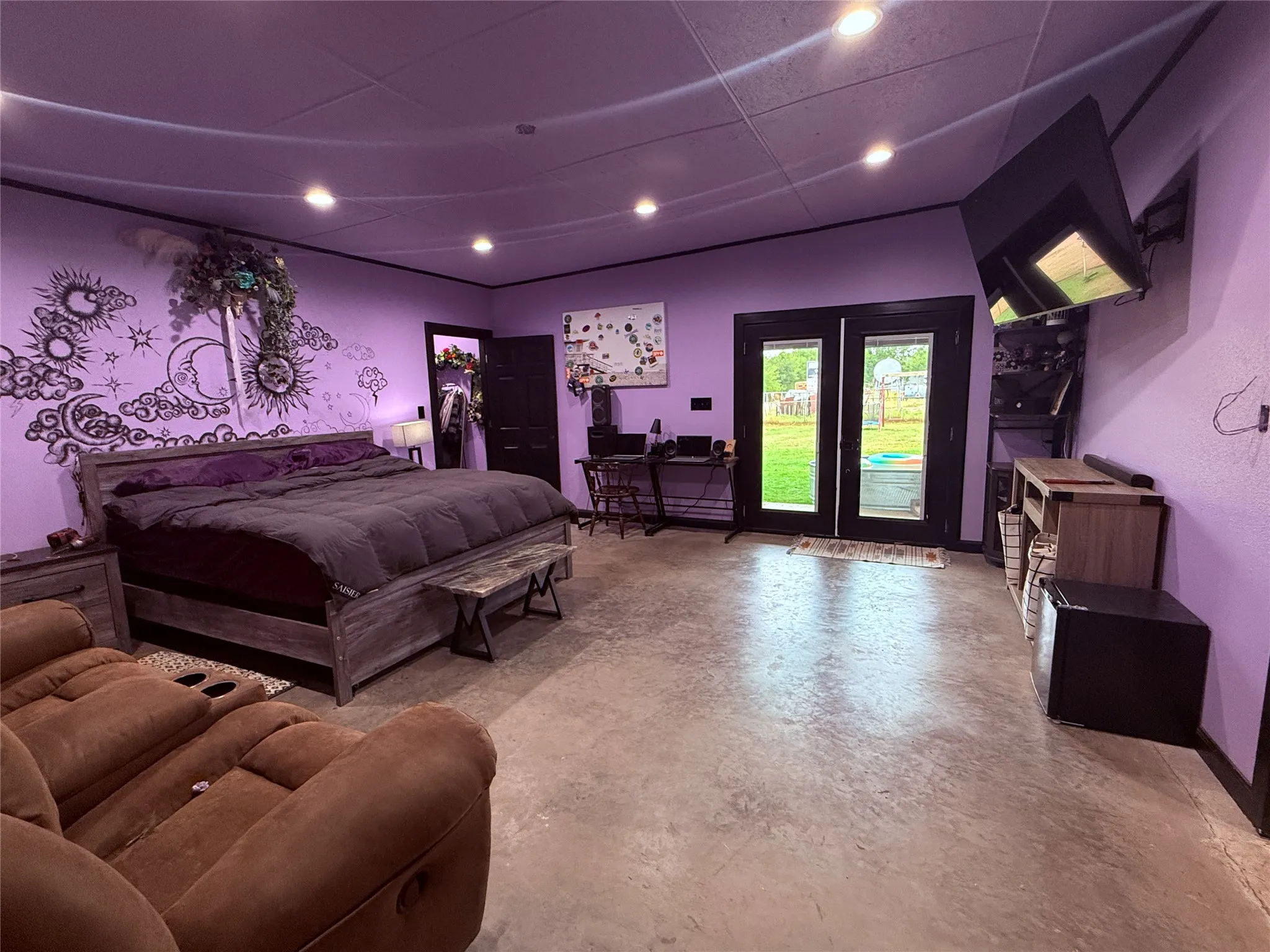 Polished concrete flooring, recessed lighting, and a wall-mounted flat-screen television