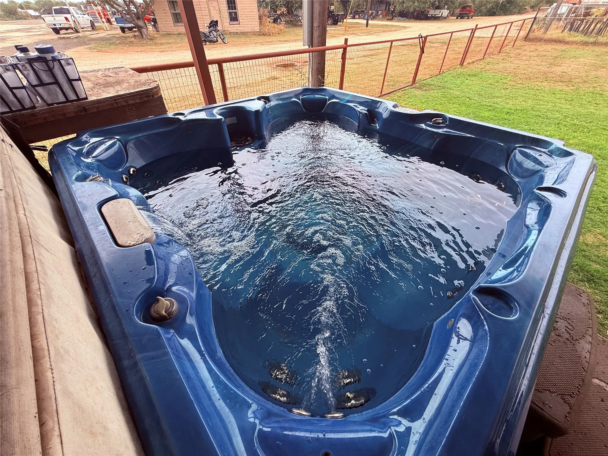 Outdoor triangular spa with integrated seating and bubbling water feature