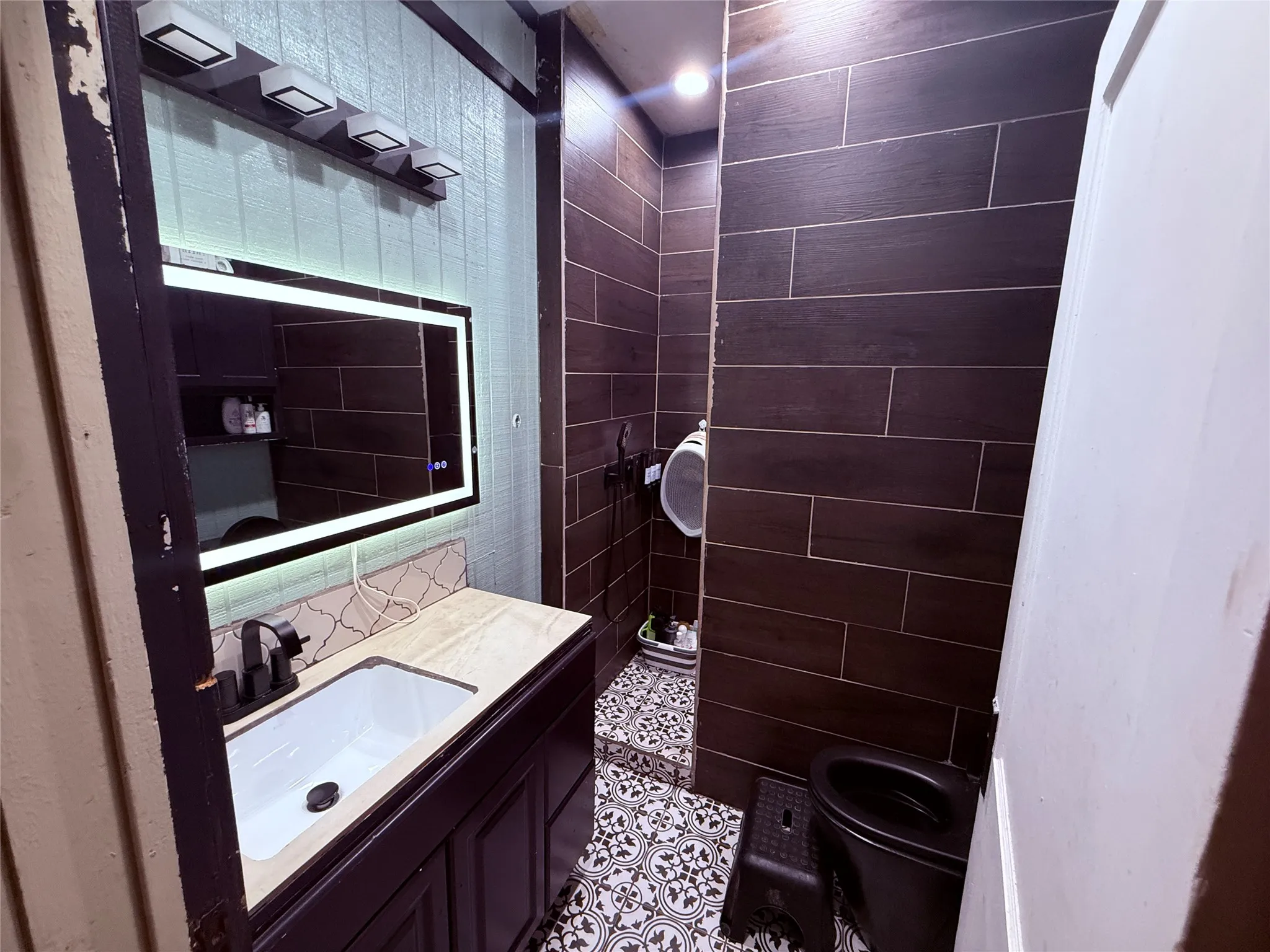 Vanity with an integrated sink, black faucet, and stone-finish countertop