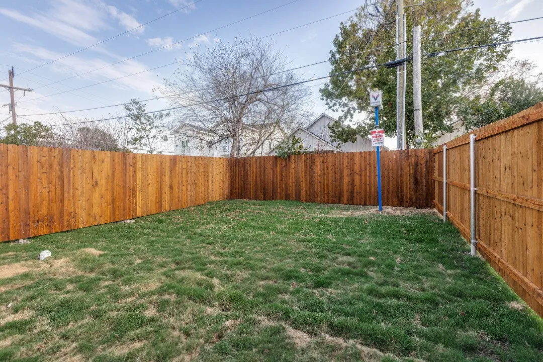 Fenced yard with a grassy area and wood fencing