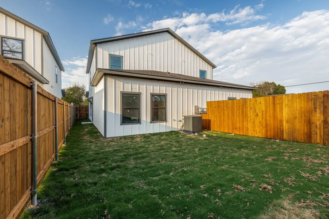 Grassed yard area bordered by a wood privacy fence