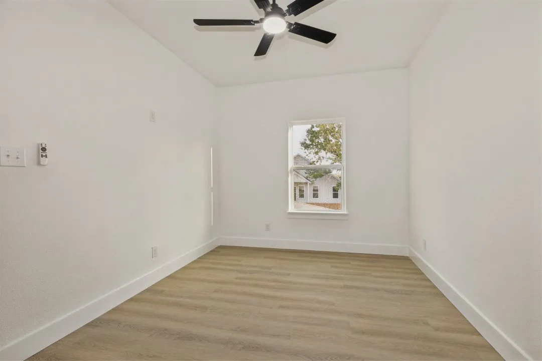 Recessed lighting, wood-finish flooring, ceiling fan with light fixture, and a window with exterior scenery
