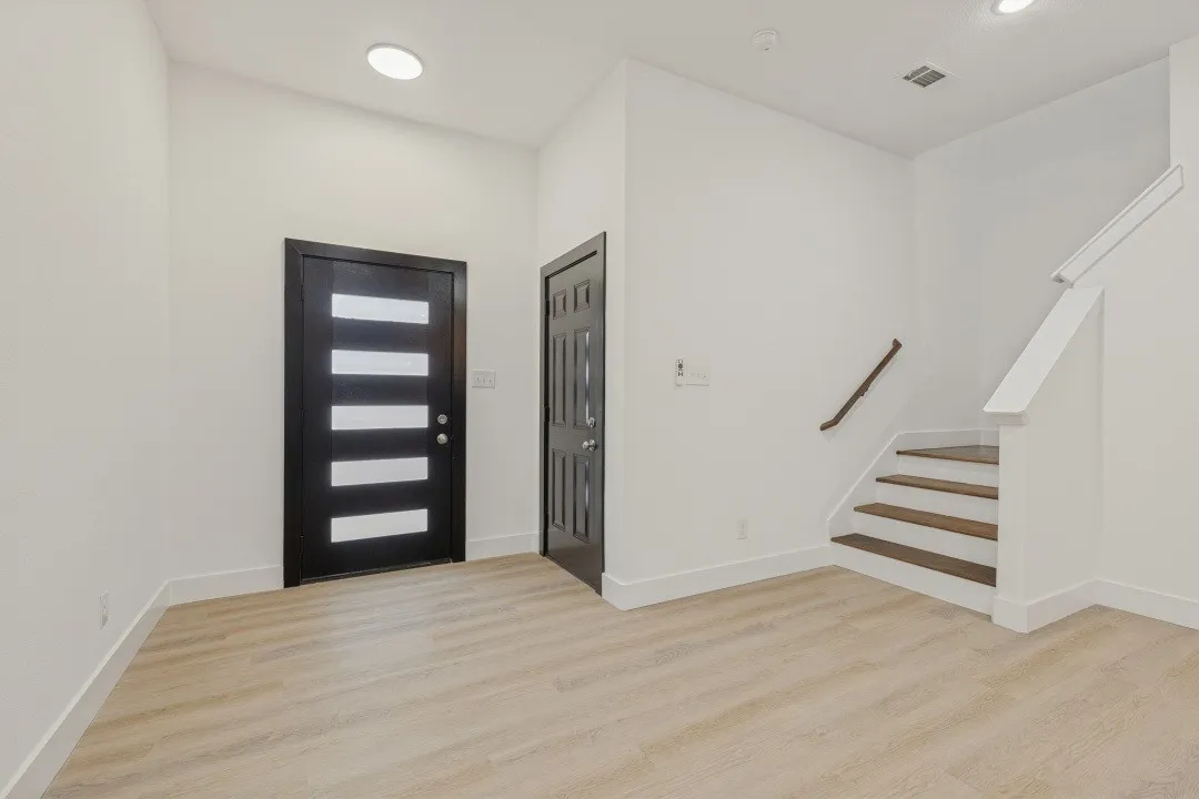 Light wood-finish flooring with white baseboards throughout