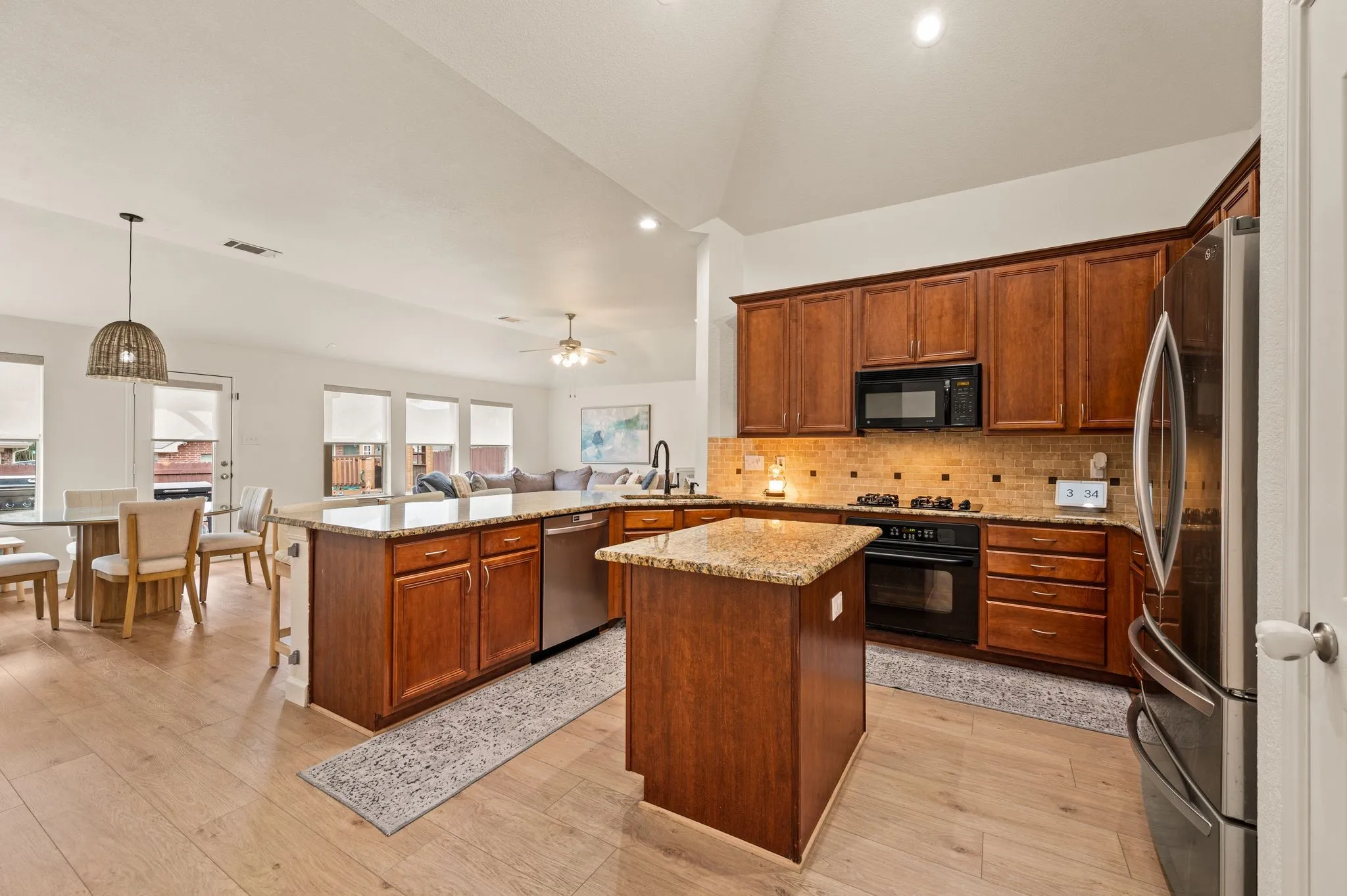 Kitchen featuring wood-finish cabinetry, stainless steel appliances, a center island, and a tile backsplash