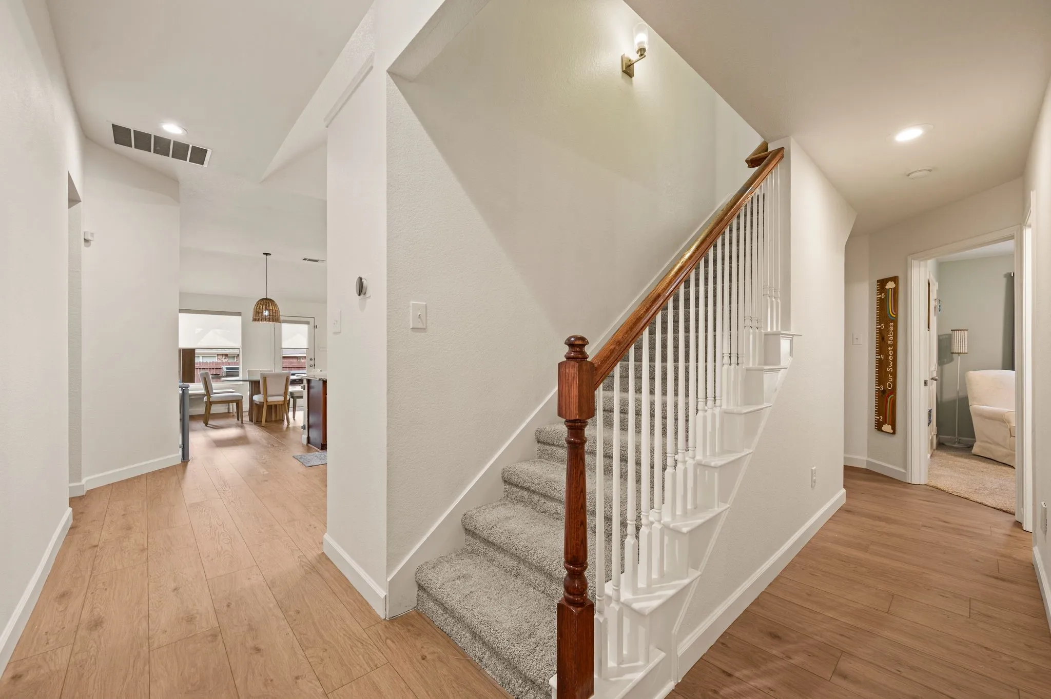 Central staircase with carpeted treads and a wood handrail