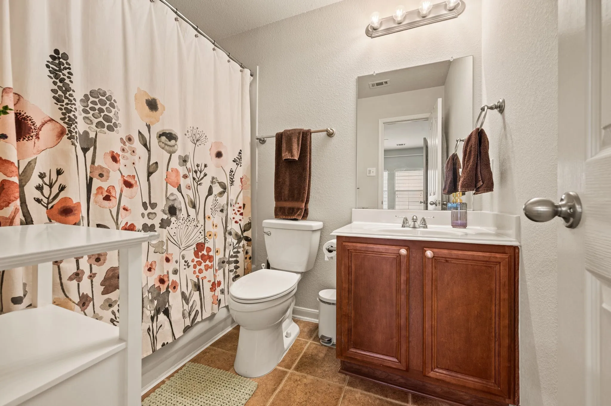 Bathroom featuring a single vanity with wood-finish cabinetry, a white countertop, and an integrated sink