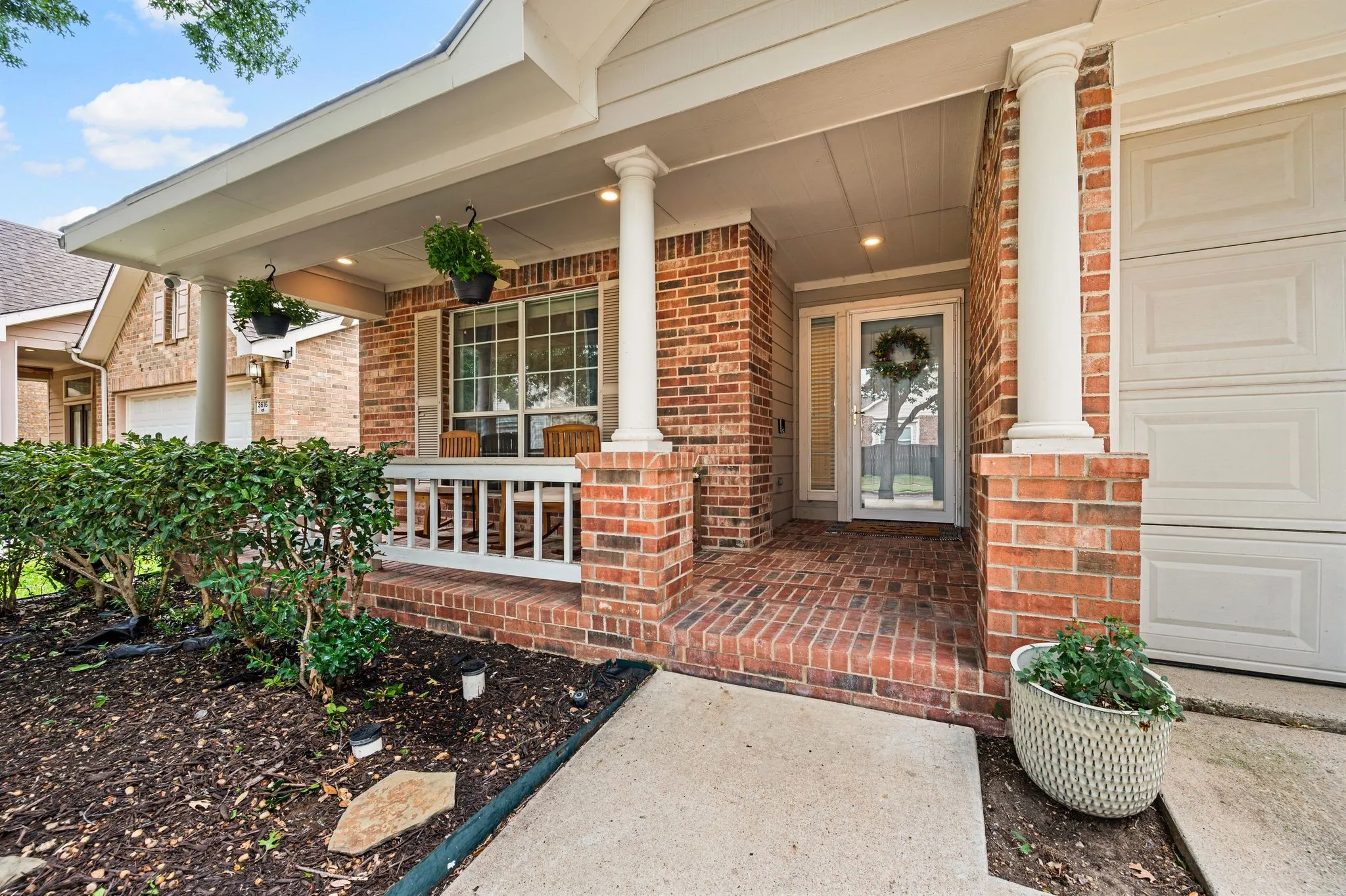 Brick exterior with a covered porch, white columns, and a brick-patterned floor