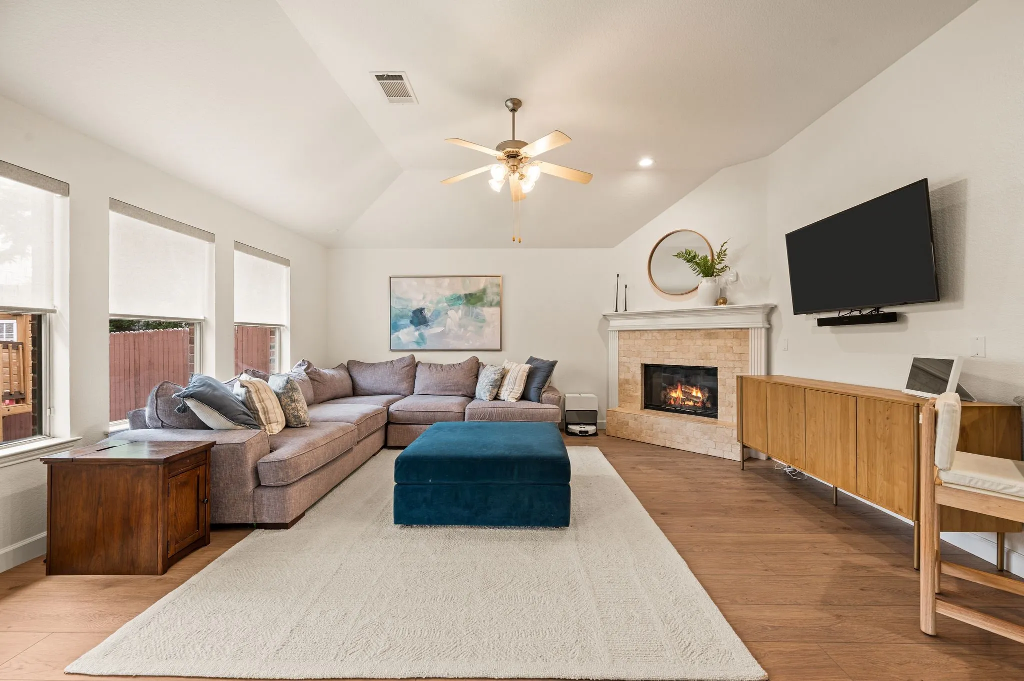 Vaulted ceilings with a ceiling fan, recessed lighting, and wood-finish flooring