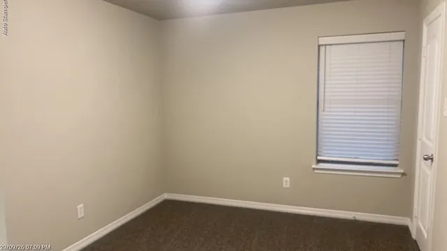 Neutral wall tones, carpeted flooring, window with blinds, and white trim throughout
