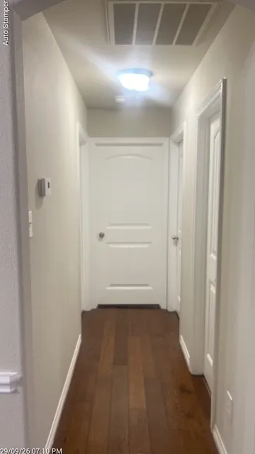Wood-finish flooring, white paneled doors, ceiling-mounted light fixture, and white trim