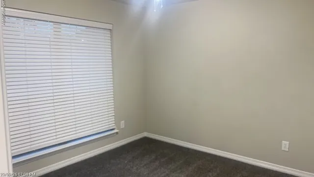 Recessed window with horizontal blinds, neutral wall paint, and gray carpet
