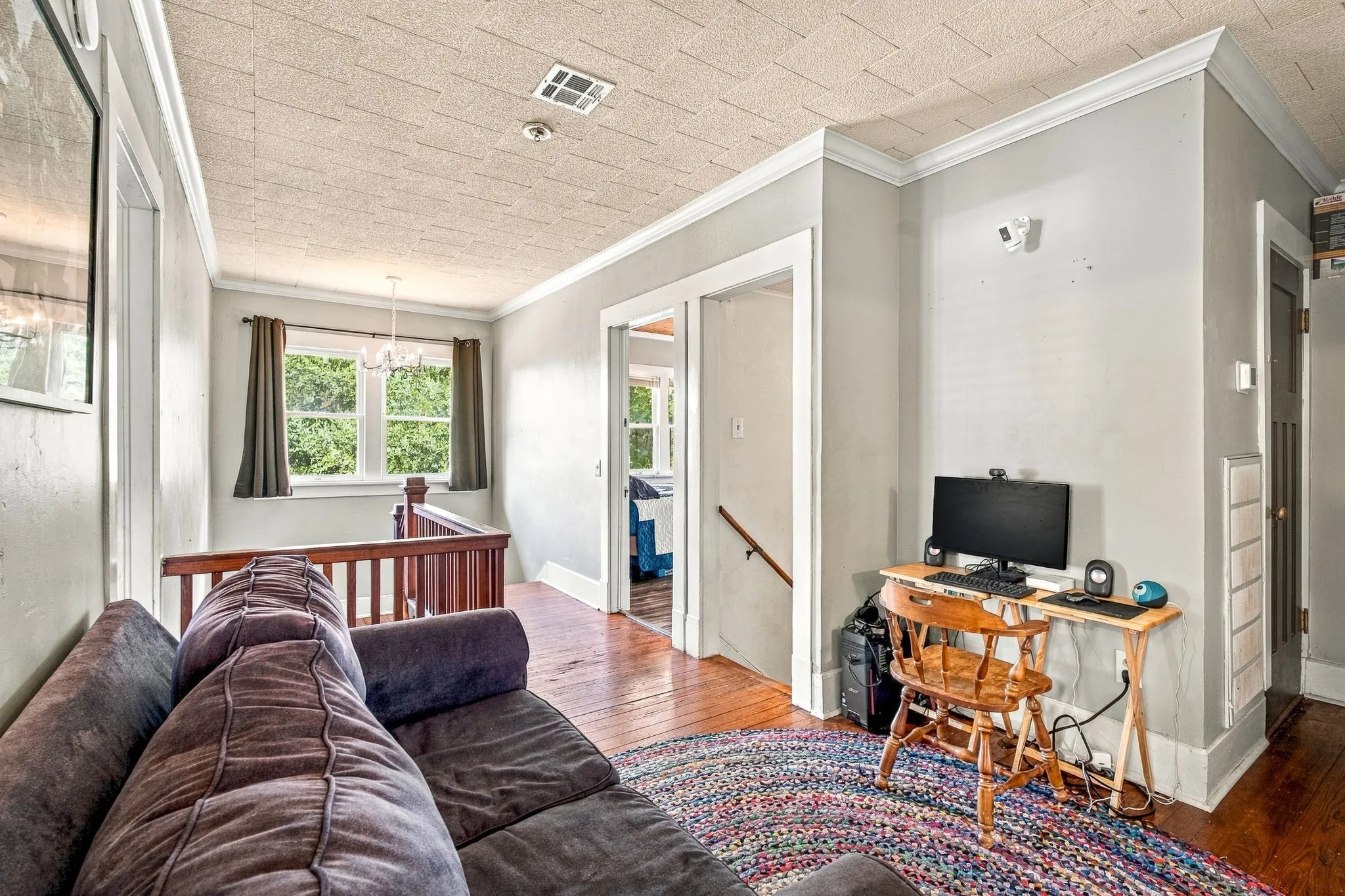 Hardwood flooring, crown molding, white trim, and a textured ceiling