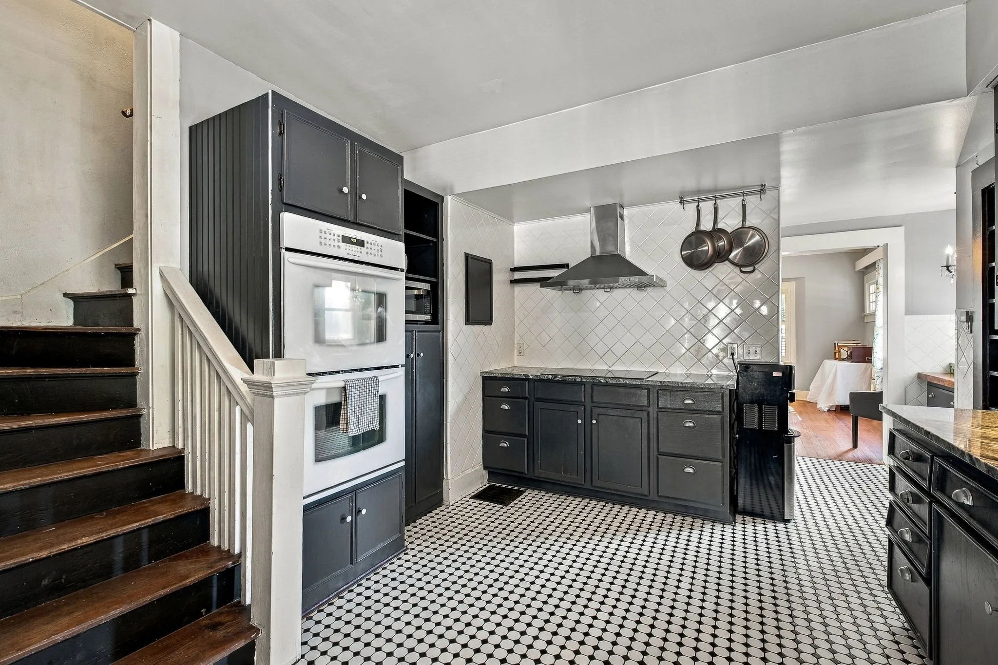 Kitchen featuring black cabinetry, a built-in double oven, and a mosaic tile floor