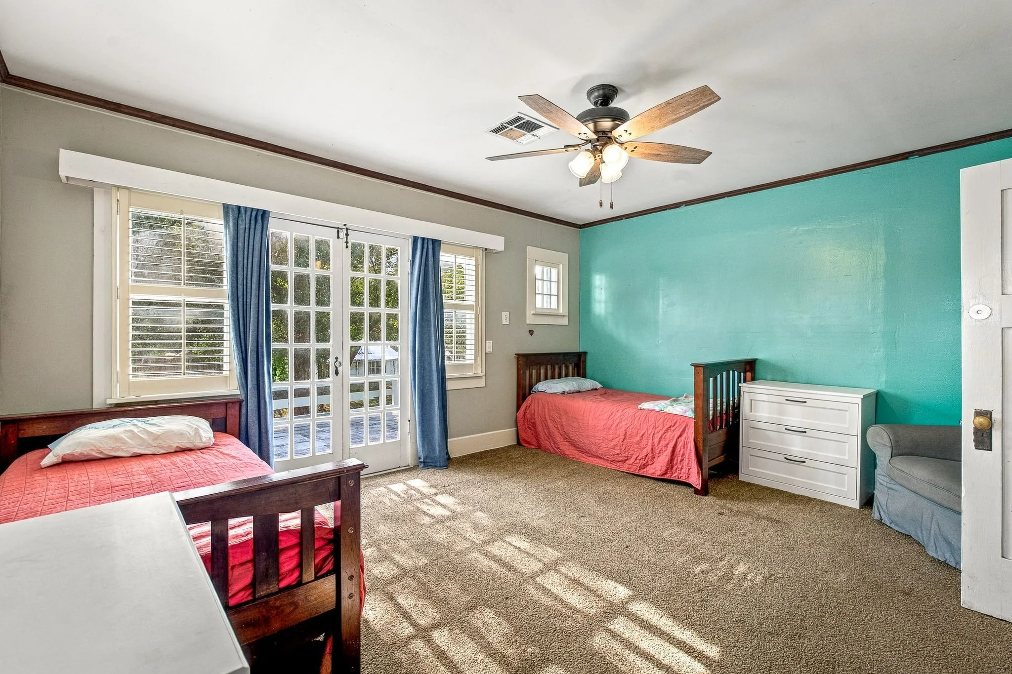 Carpeted room featuring a ceiling fan, French doors, and multiple windows