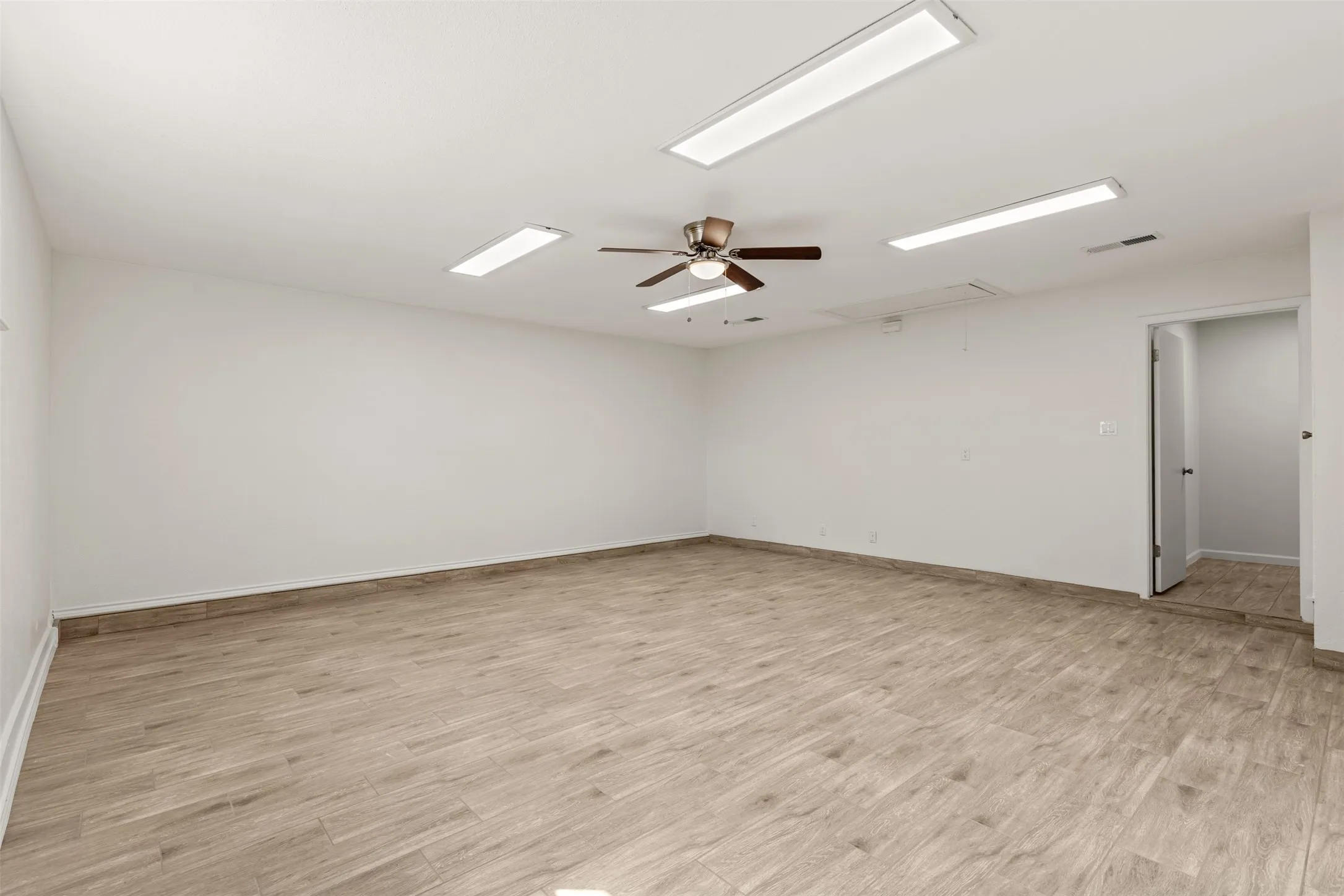 Spacious room with wood-finish flooring