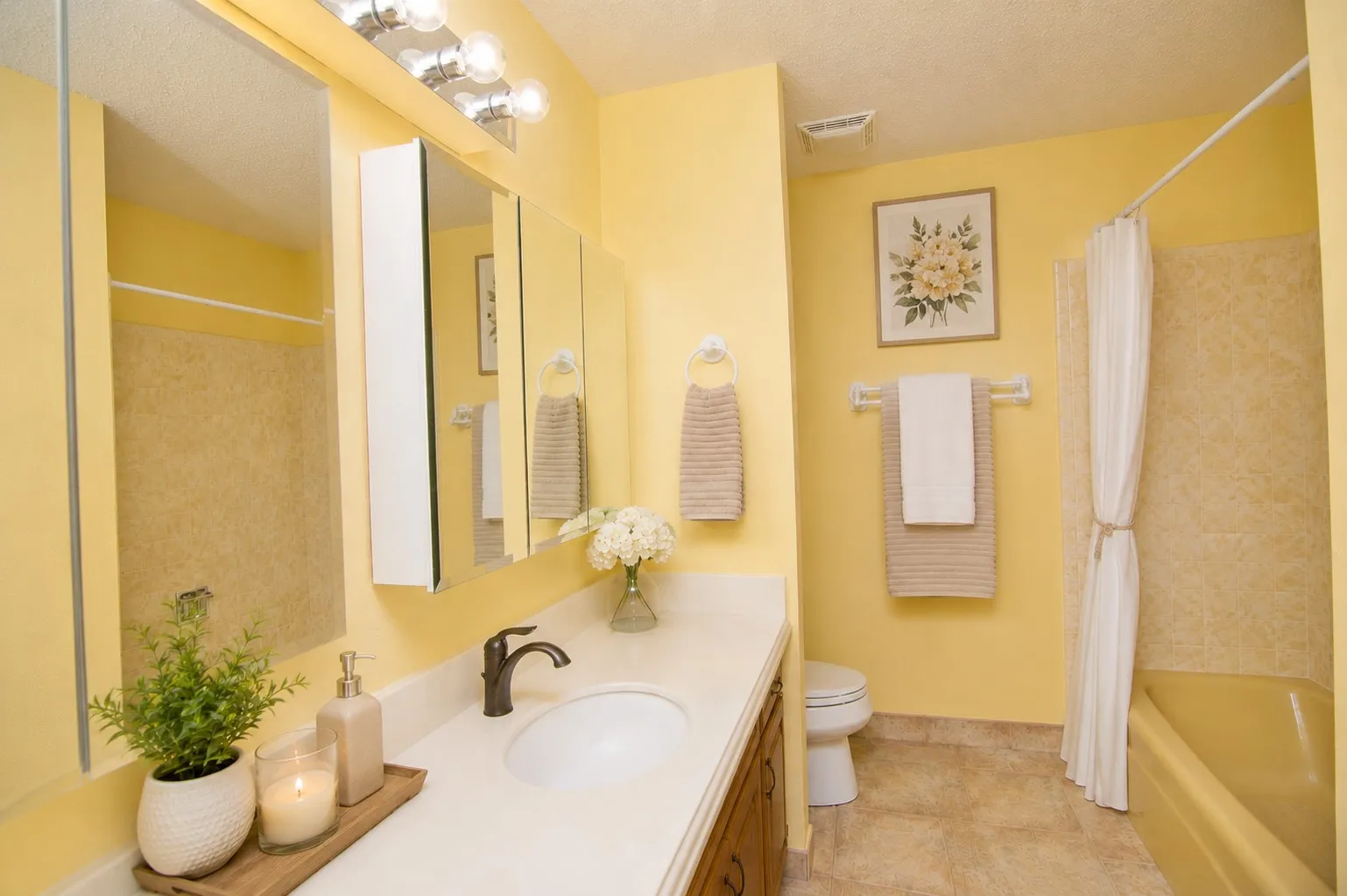 Vanity with a single basin sink, bronze-finish faucet, and white countertop