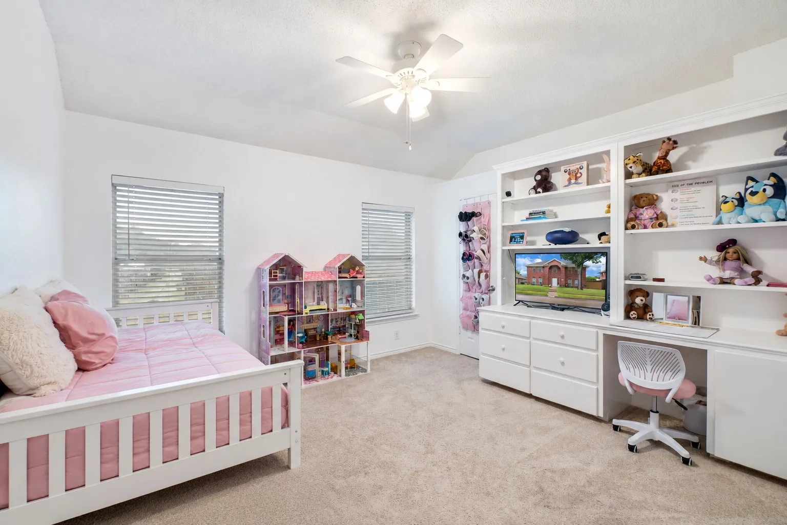 Bedroom 3 Carpeted bedroom featuring white walls, dual windows with blinds, a built-in shelving unit, and a ceiling fan