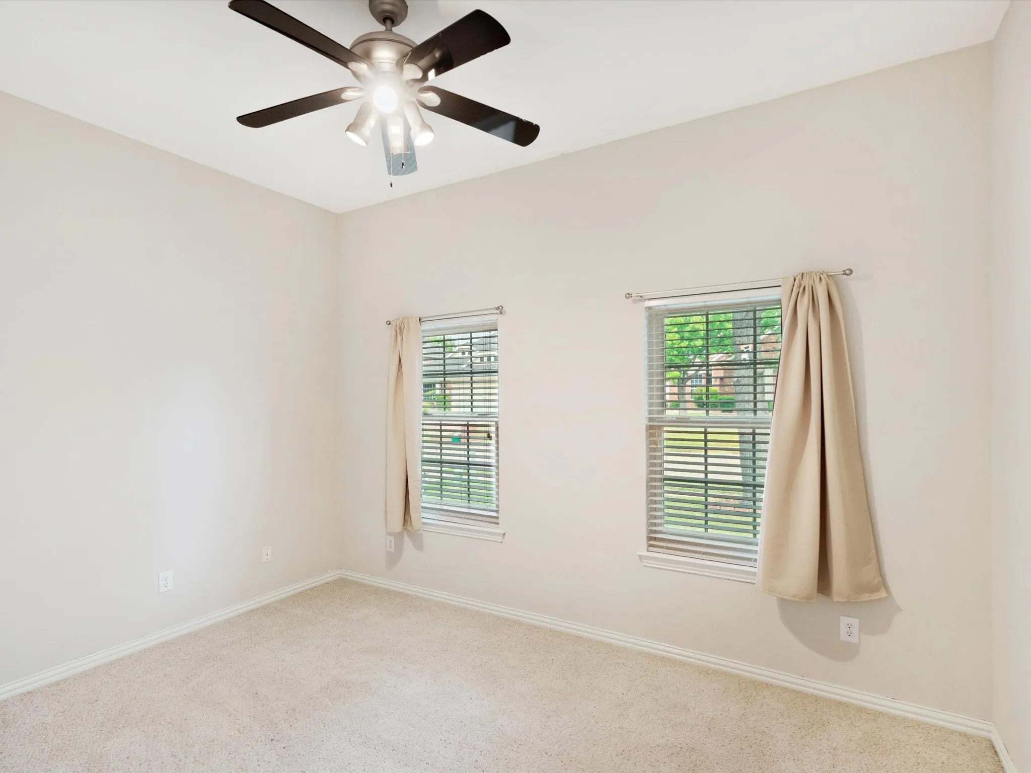 Neutral tone walls, ceiling fan with integrated lighting, window with blinds, window with curtains, and carpet flooring