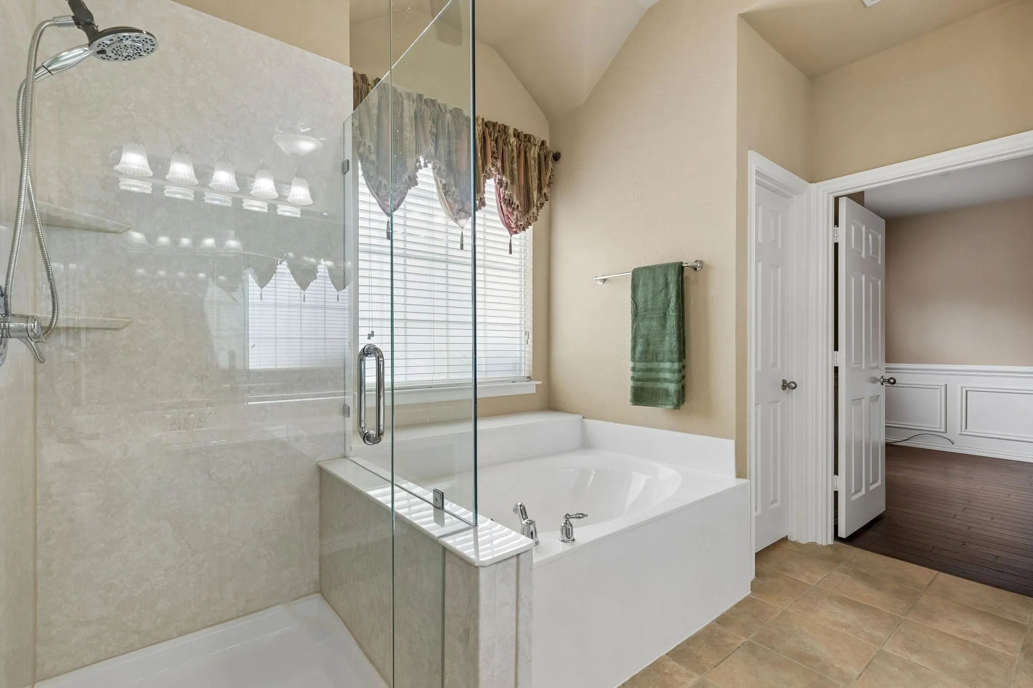 Glass-enclosed shower with and light-toned tile surround
