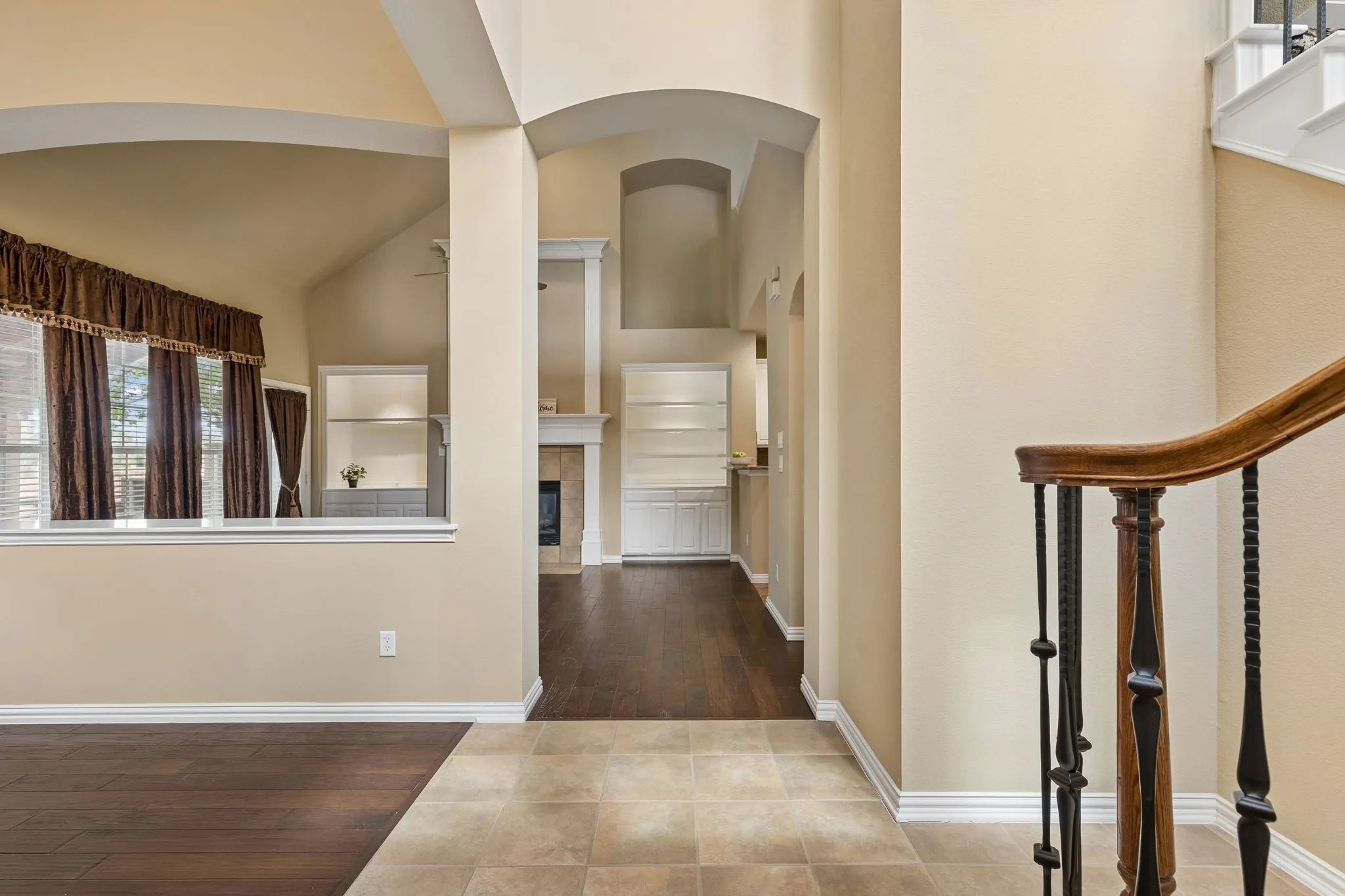 Arched entryway leading to a living area with a gas fireplace and built-in shelving