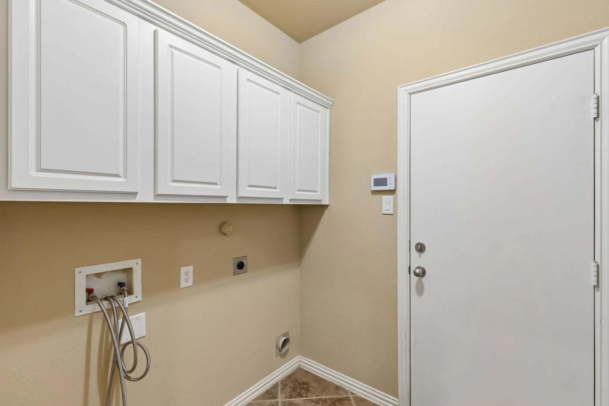 White upper cabinetry with more storage and work counter behind the door.