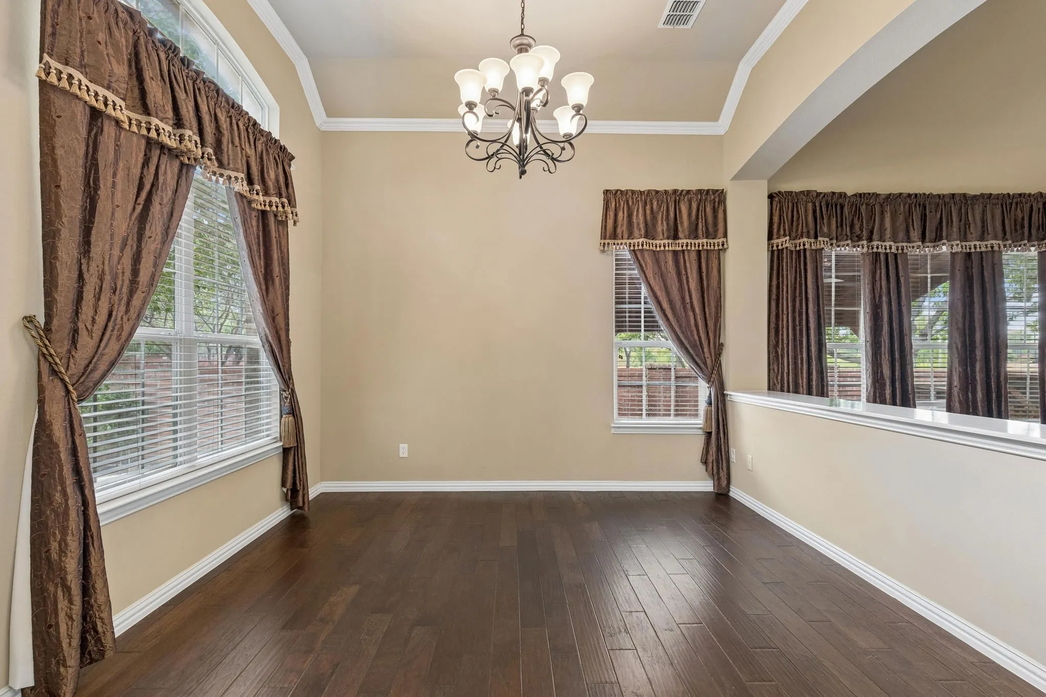Recessed ceiling, dark wood-finish flooring, and white trim