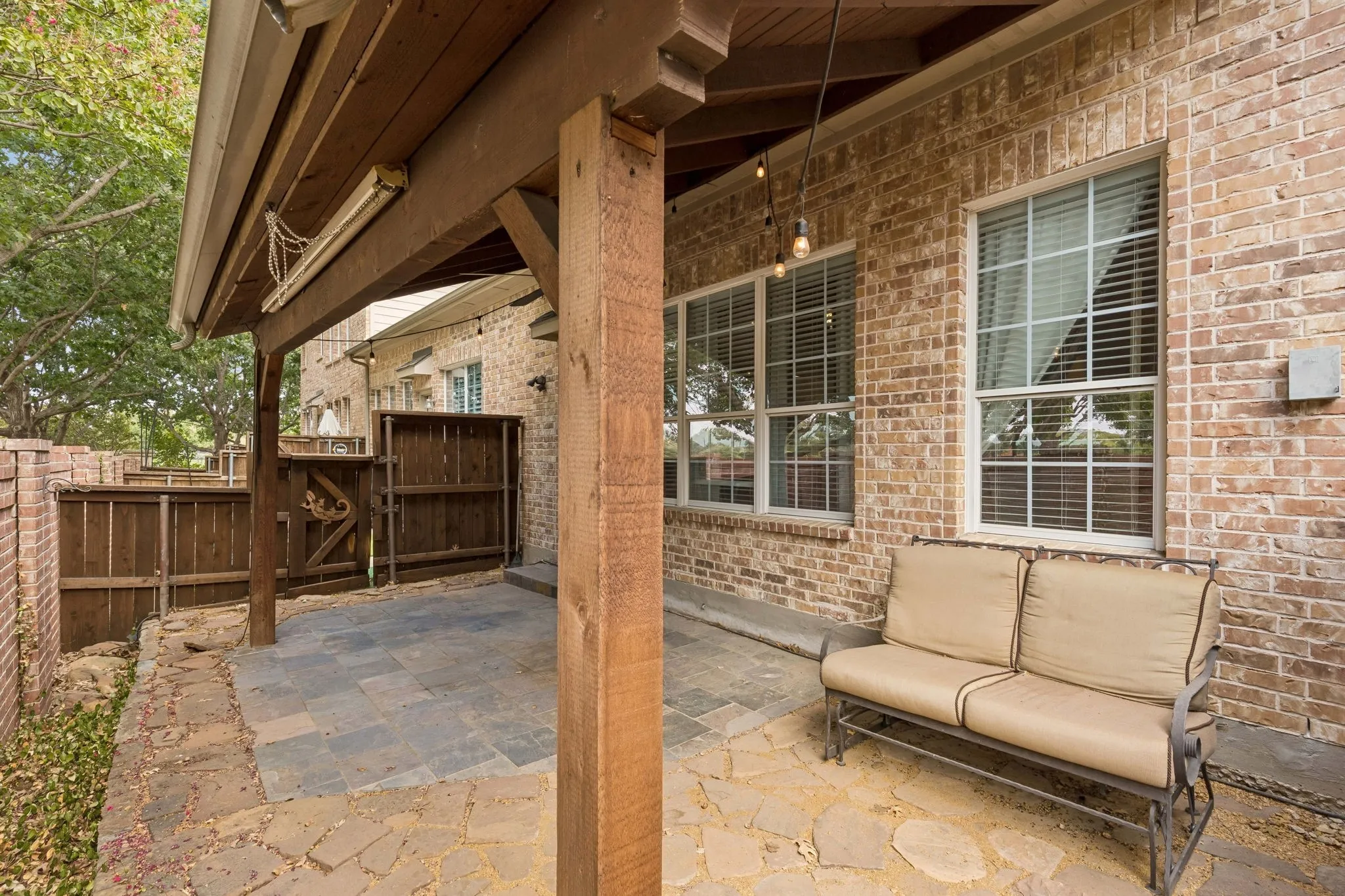 Covered patio featuring wood columns, decorative lights and a pull down screen for those August sunsets