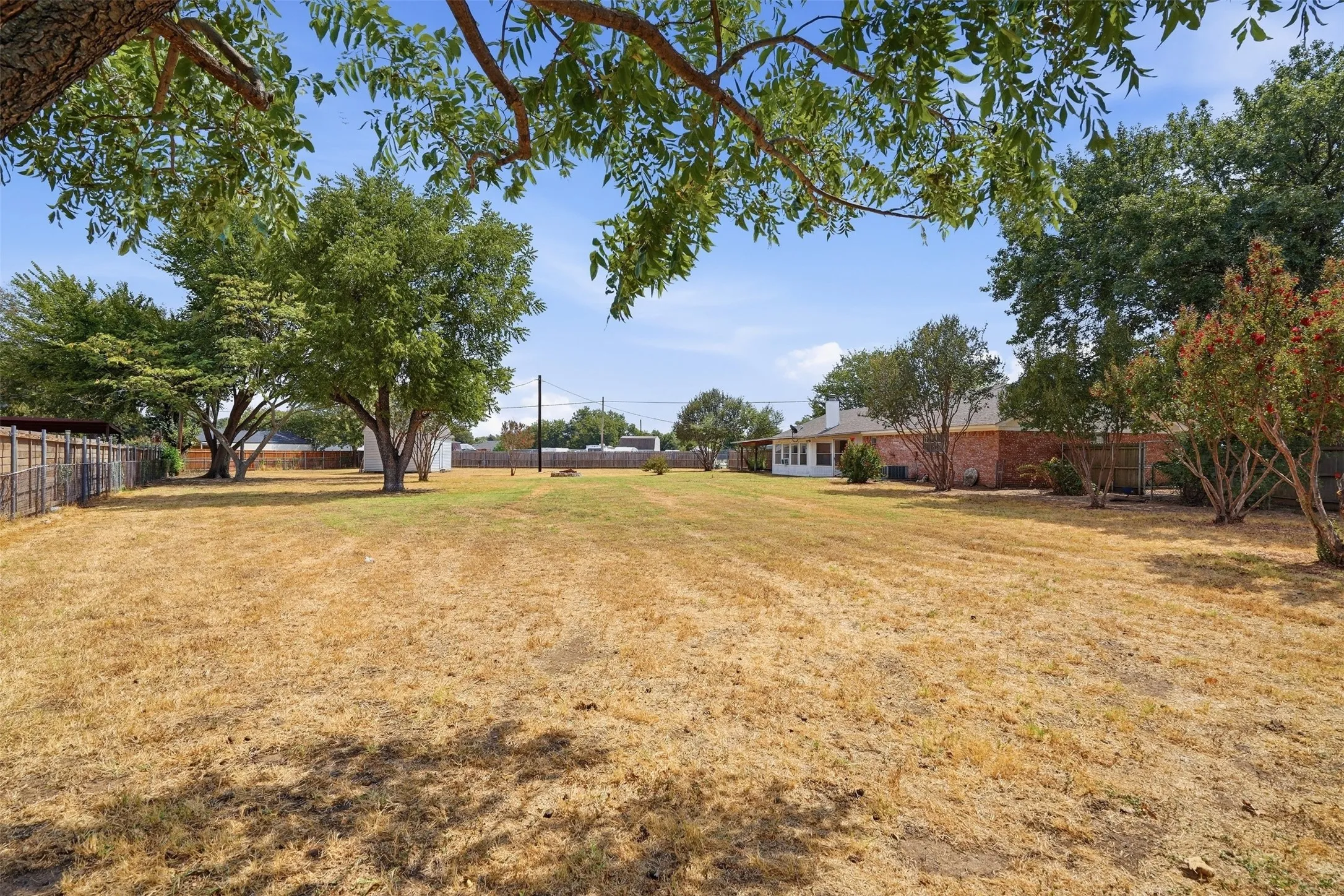 Expansive lot with mature trees and a fenced perimeter