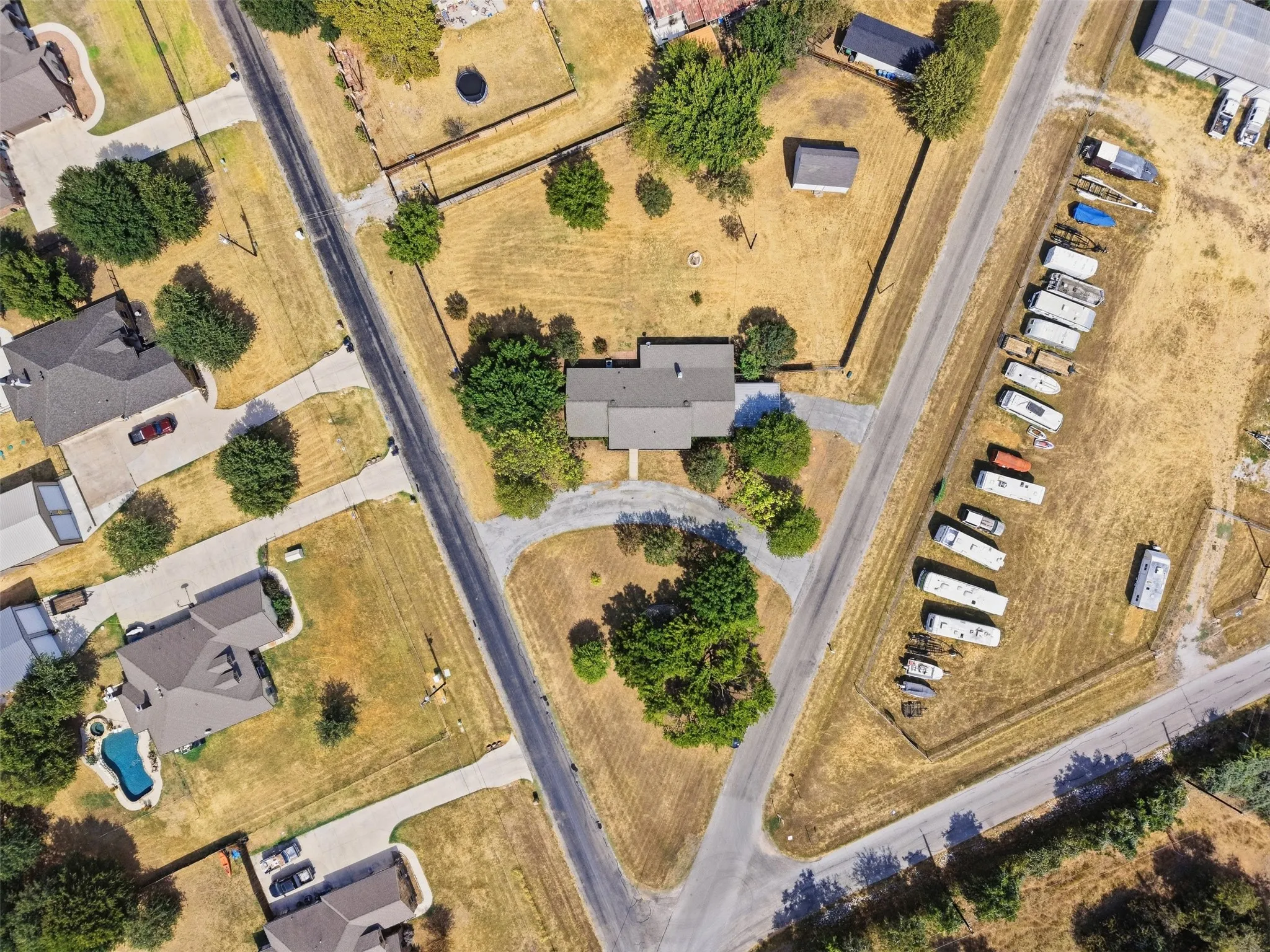 Expansive property featuring a central residence, gravel driveways, and mature landscaping