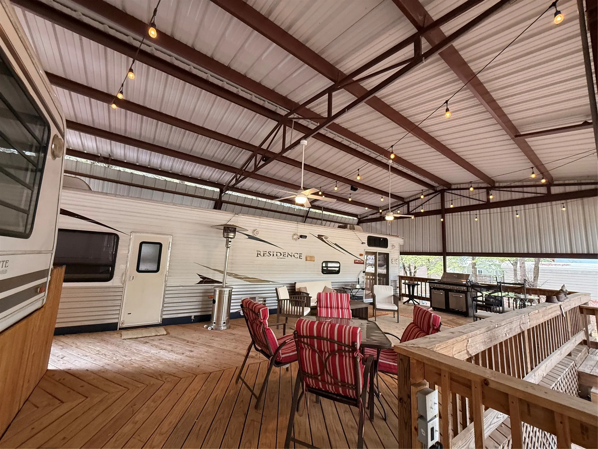 Expansive covered deck featuring a metal roof structure, wood-finish flooring, and exposed rafters