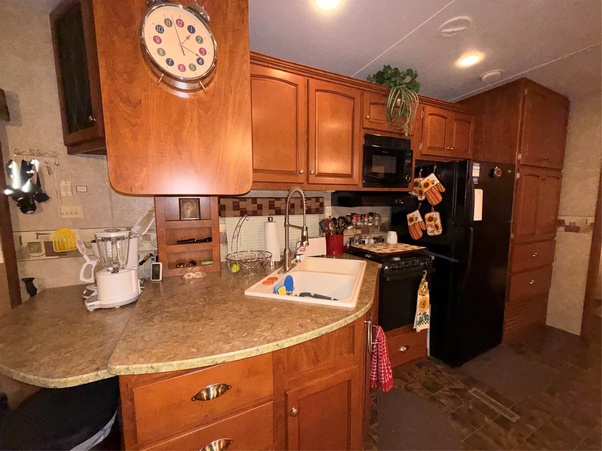 Kitchen featuring wood-finish cabinetry, solid surface countertops, and a tile backsplash