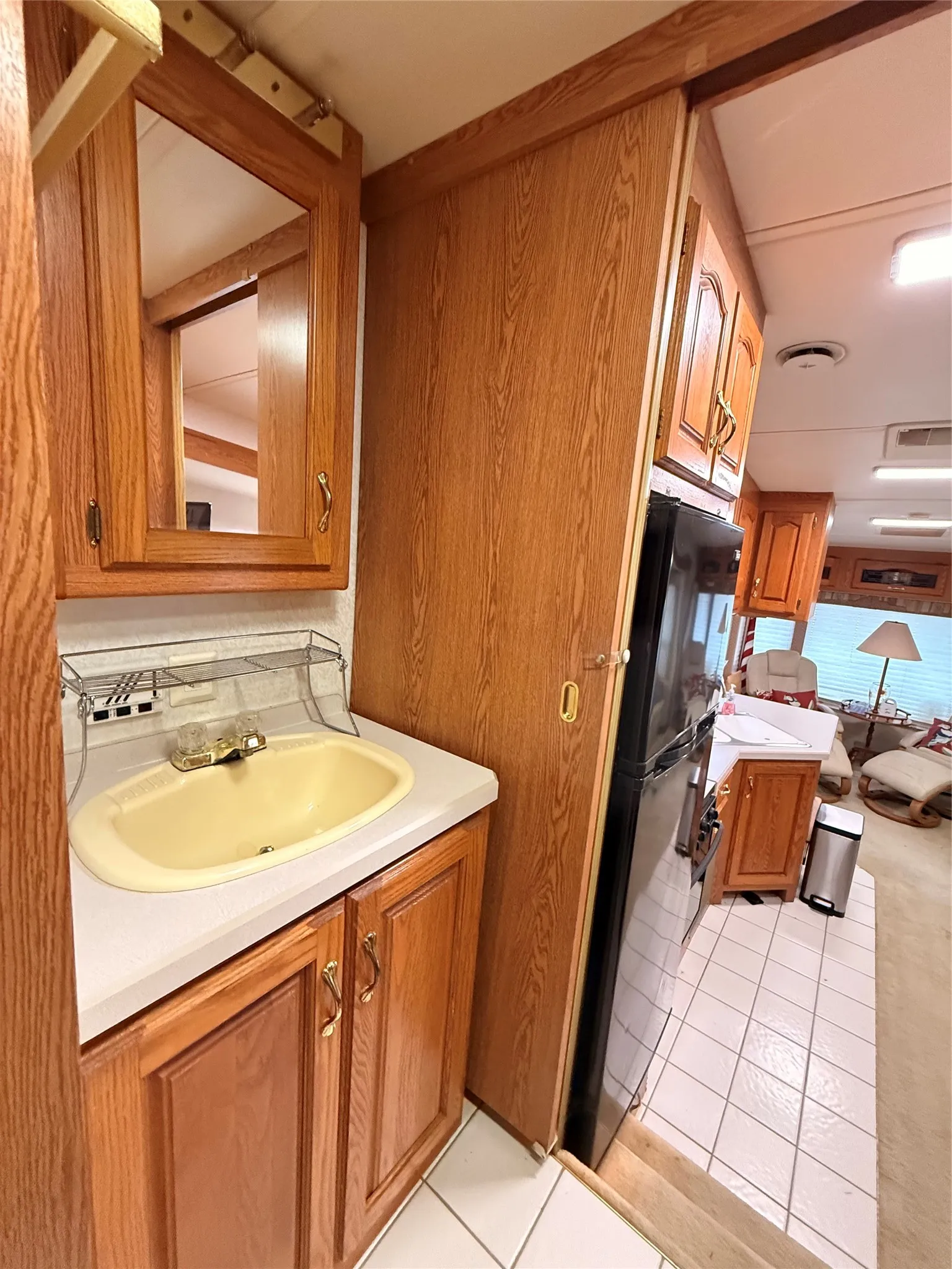 Vanity with a vessel sink, wood-finish cabinetry, and a mirrored medicine cabinet