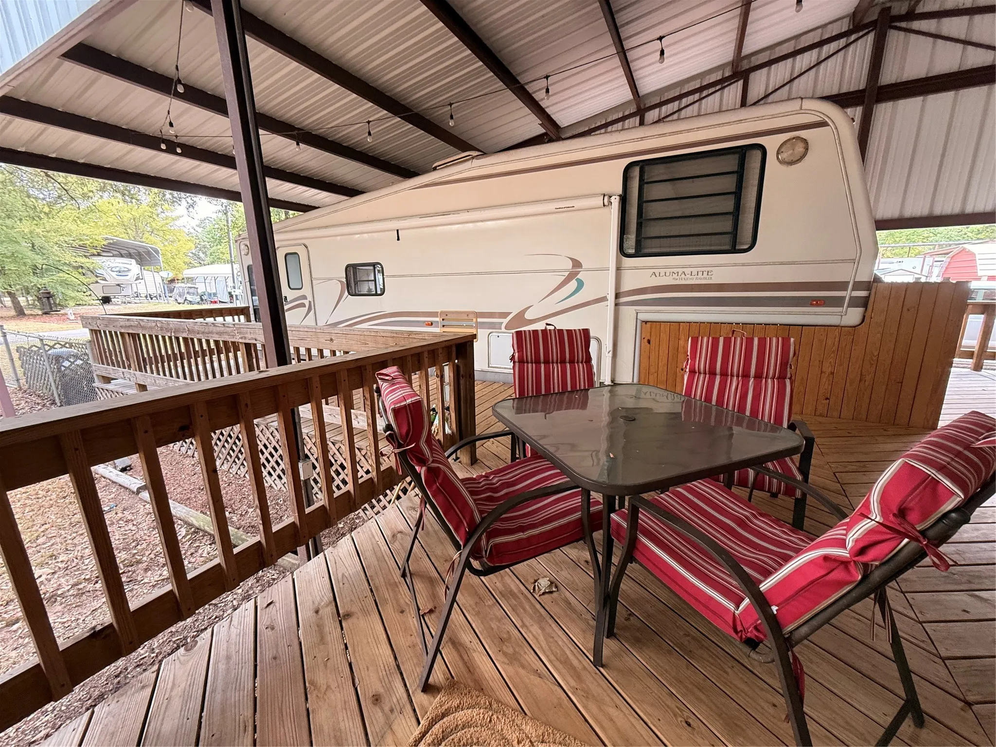 Expansive wood-finish deck with a wood railing and a metal overhang