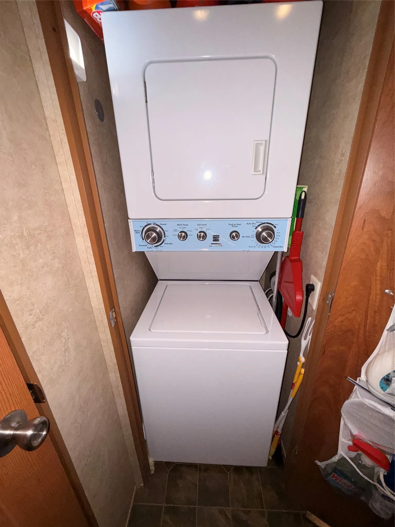 Stacked white washer and dryer unit with blue control panel