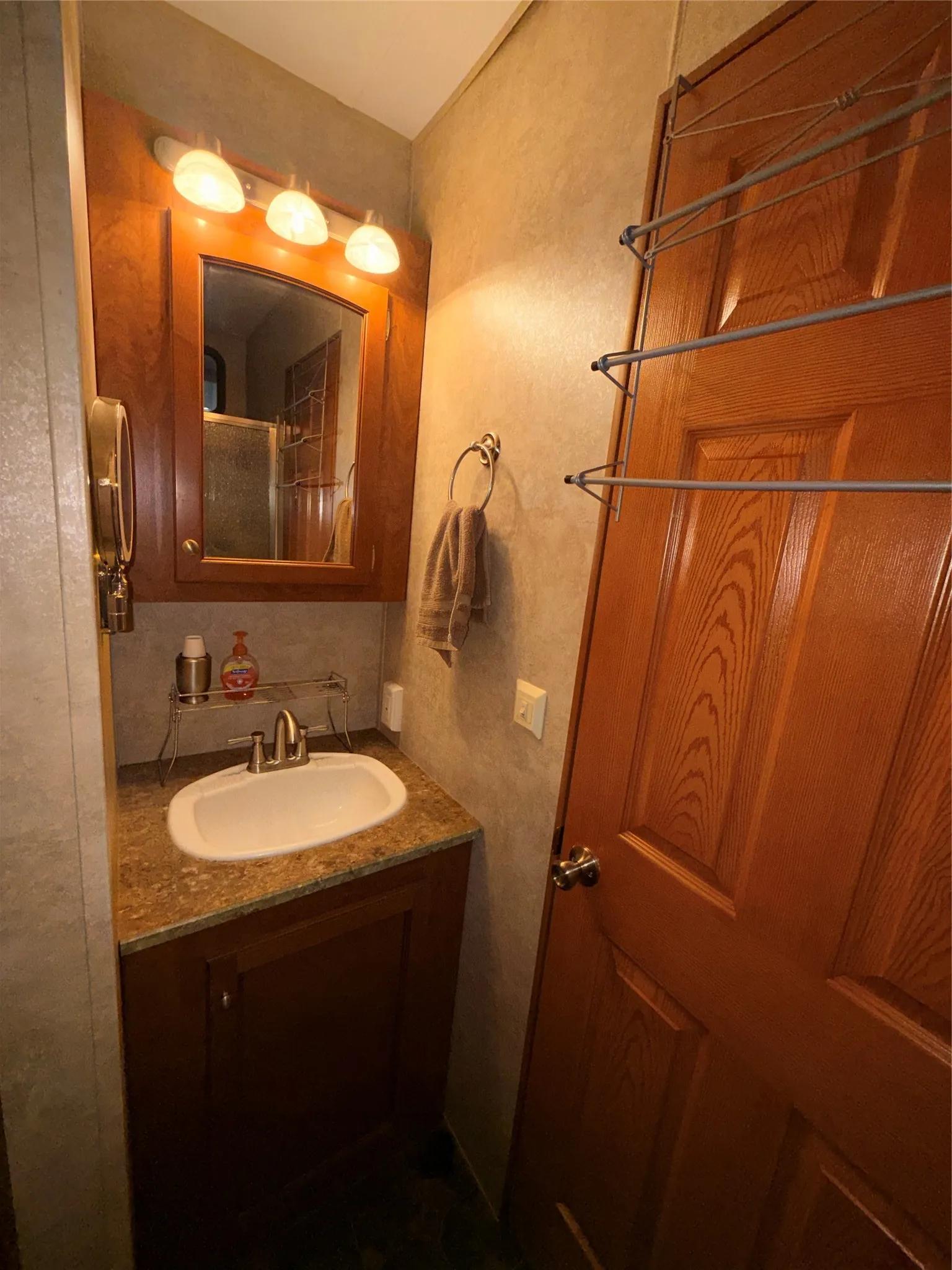 Wood-finish vanity with an integrated sink and brushed nickel faucet