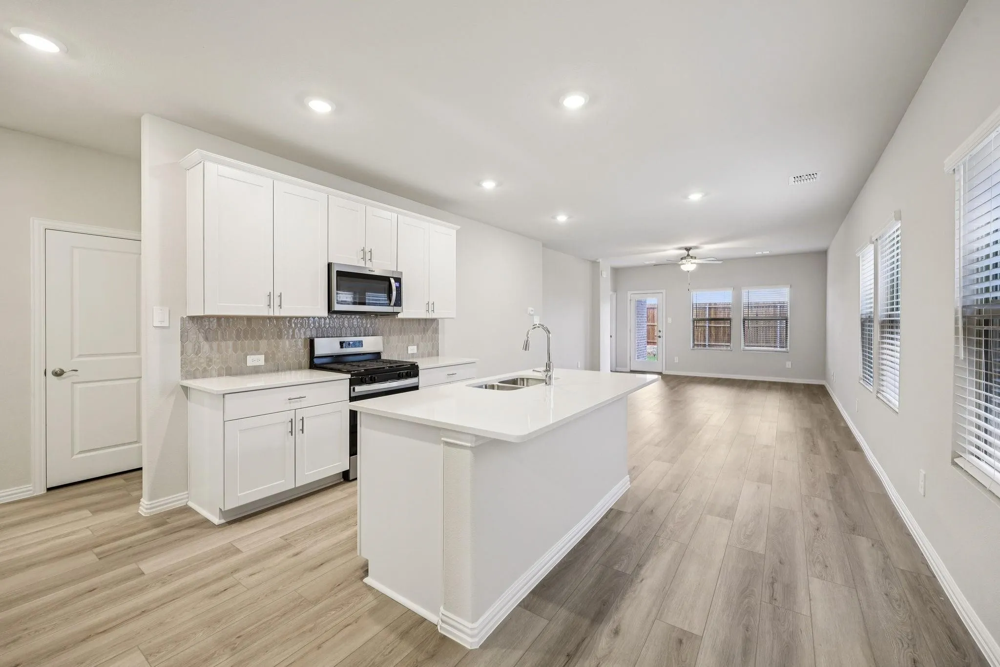 Modern kitchen with white cabinetry and an island featuring an undermount sink