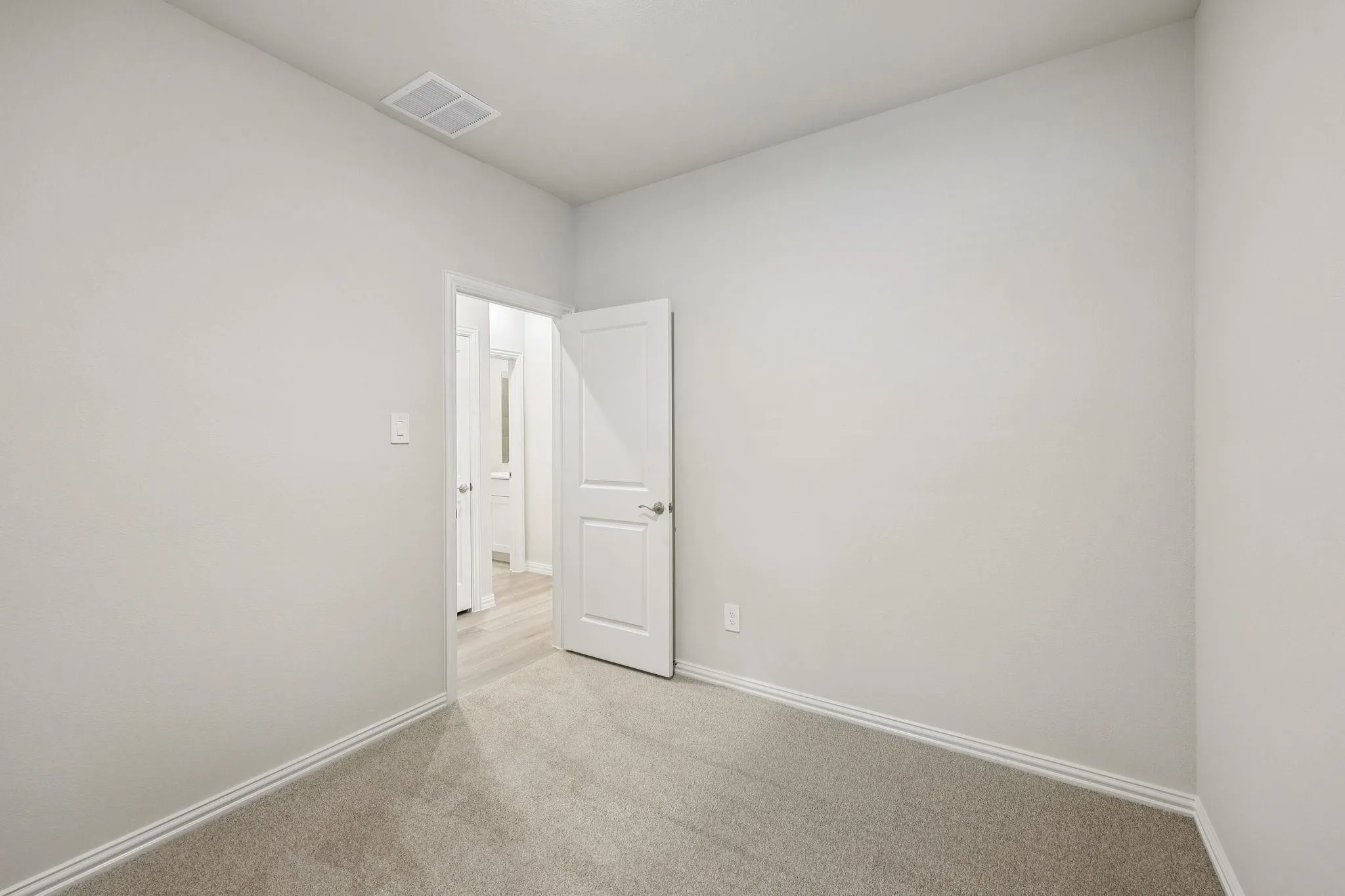 Neutral-toned carpeting, white interior doors, and a white ceiling
