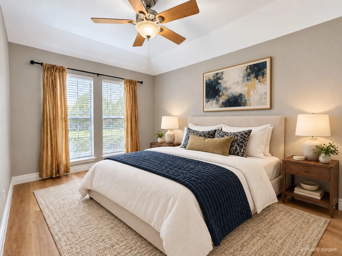 Tray ceiling with a ceiling fan, two windows with blinds, and wood-finish flooring