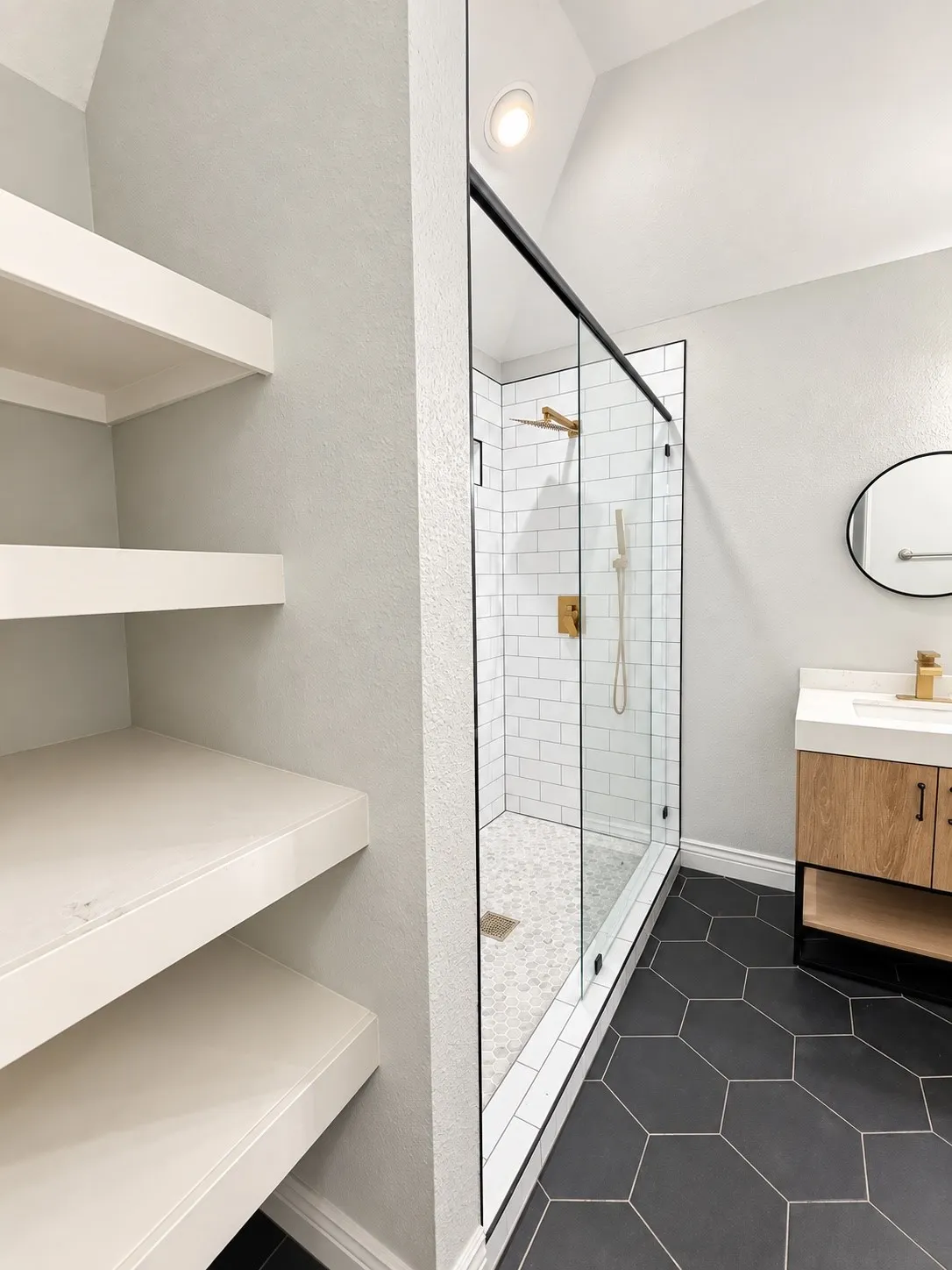 Walk-in shower with clear glass enclosure, white subway tile, and mosaic tile floor