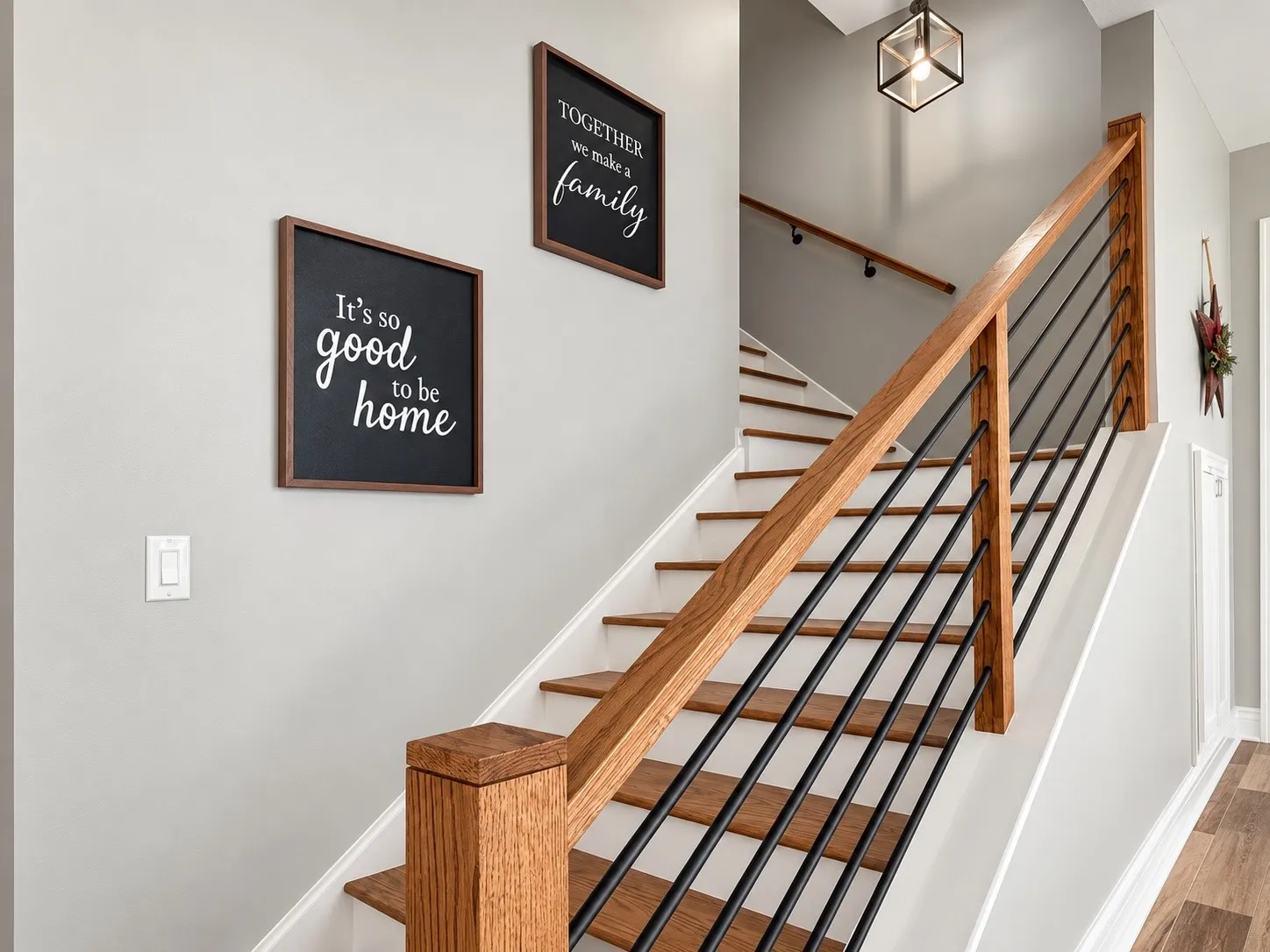 Staircase featuring wood treads, white risers, a wood handrail, and black metal balusters