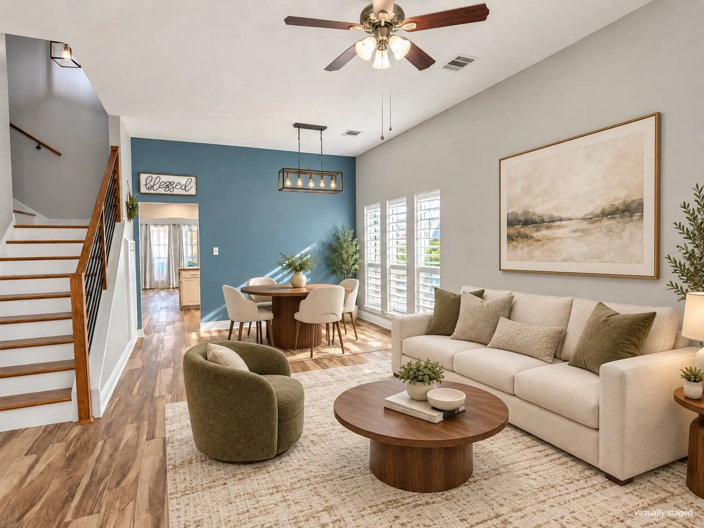 Wood-finish flooring throughout, staircase with wood handrail and black metal spindles, ceiling fan with integrated lighting, recessed lighting, and a linear pendant light fixture